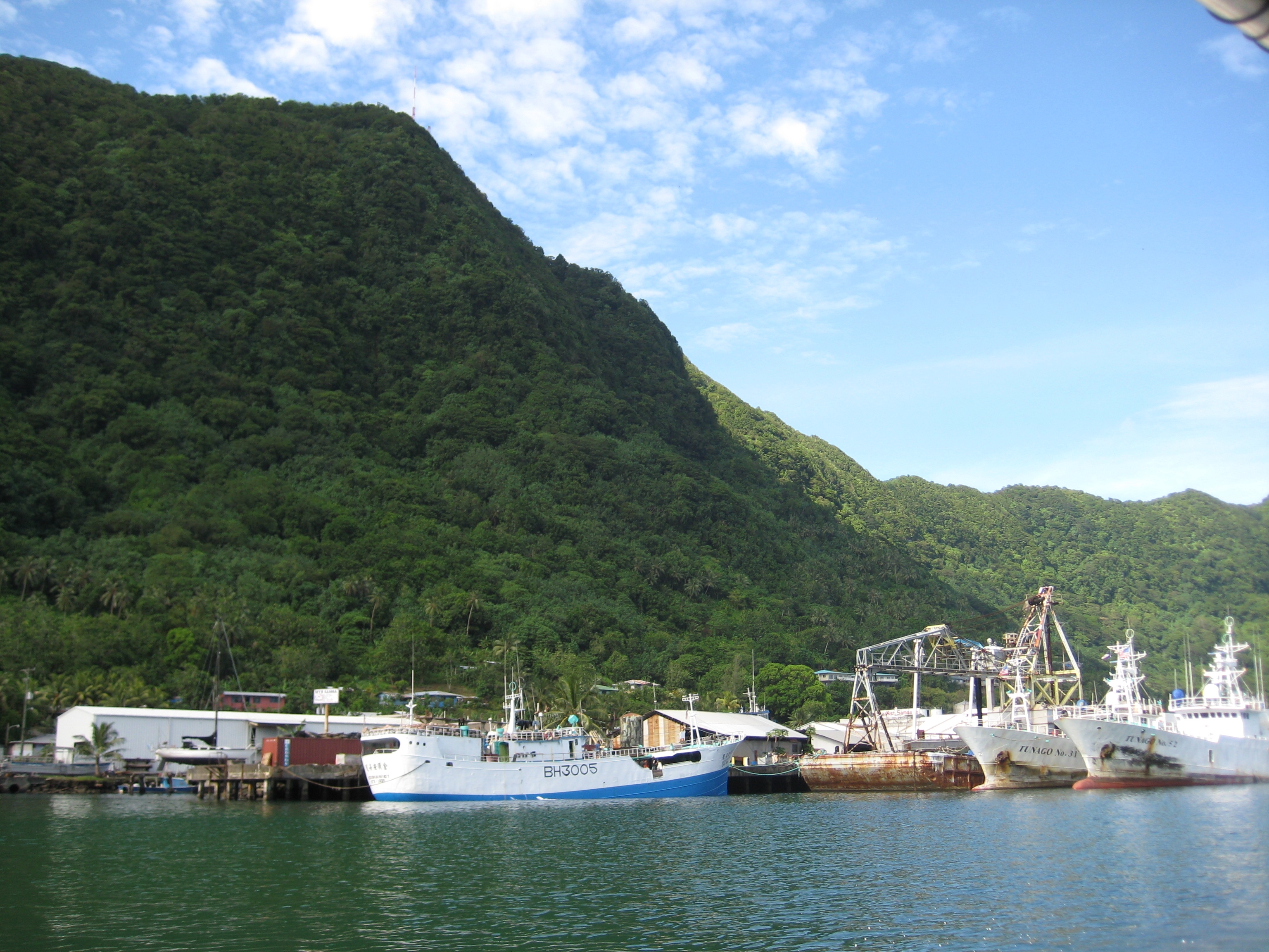 Mountains surrounding Pago Pago Harbor. Tuna boats in port. American Samoa.