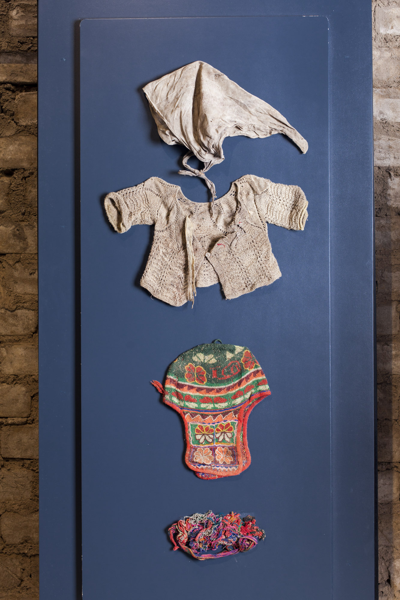 Prendas exhumadas de niños enterrados en la fosa clandestina de Putis. Donación de Sergio Condoray, Presidente de la Asociación de Víctimas de Putis al Lugar de la Memoria, la Tolerancia y la Inclusión Social. Lima, Perú.