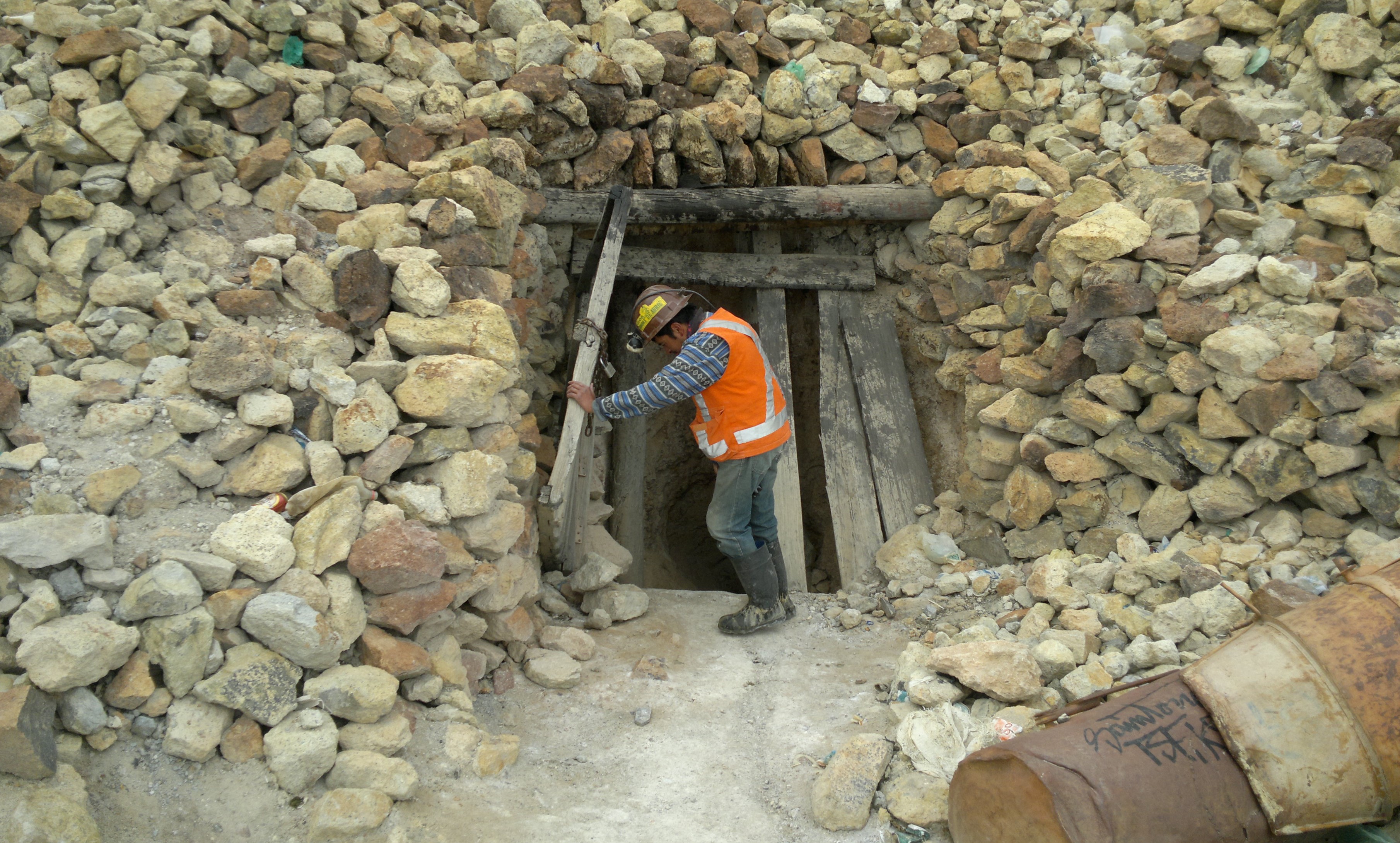 Miner opening the doors of a silver mine in "Cerro Rico", Potosí, Bolivia.