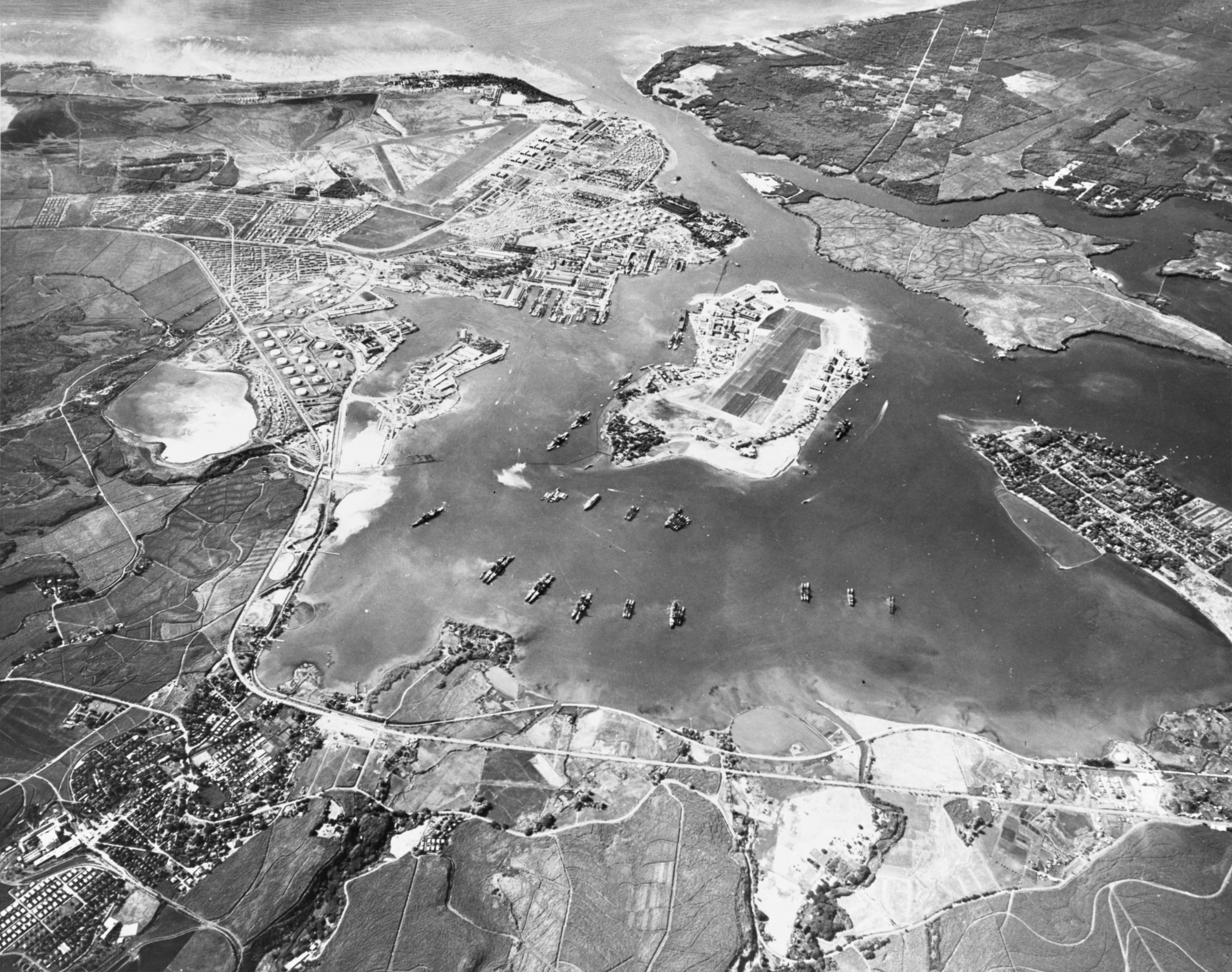 Aerial view of the U.S. Naval Operating Base, Pearl Harbor, Oahu, Hawaii (USA), looking southwest on 30 October 1941. Ford Island Naval Air Station is in the center, with the Pearl Harbor Navy Yard just beyond it, across the channel. The airfield in the upper left-center is the U.S. Army's Hickam Field.