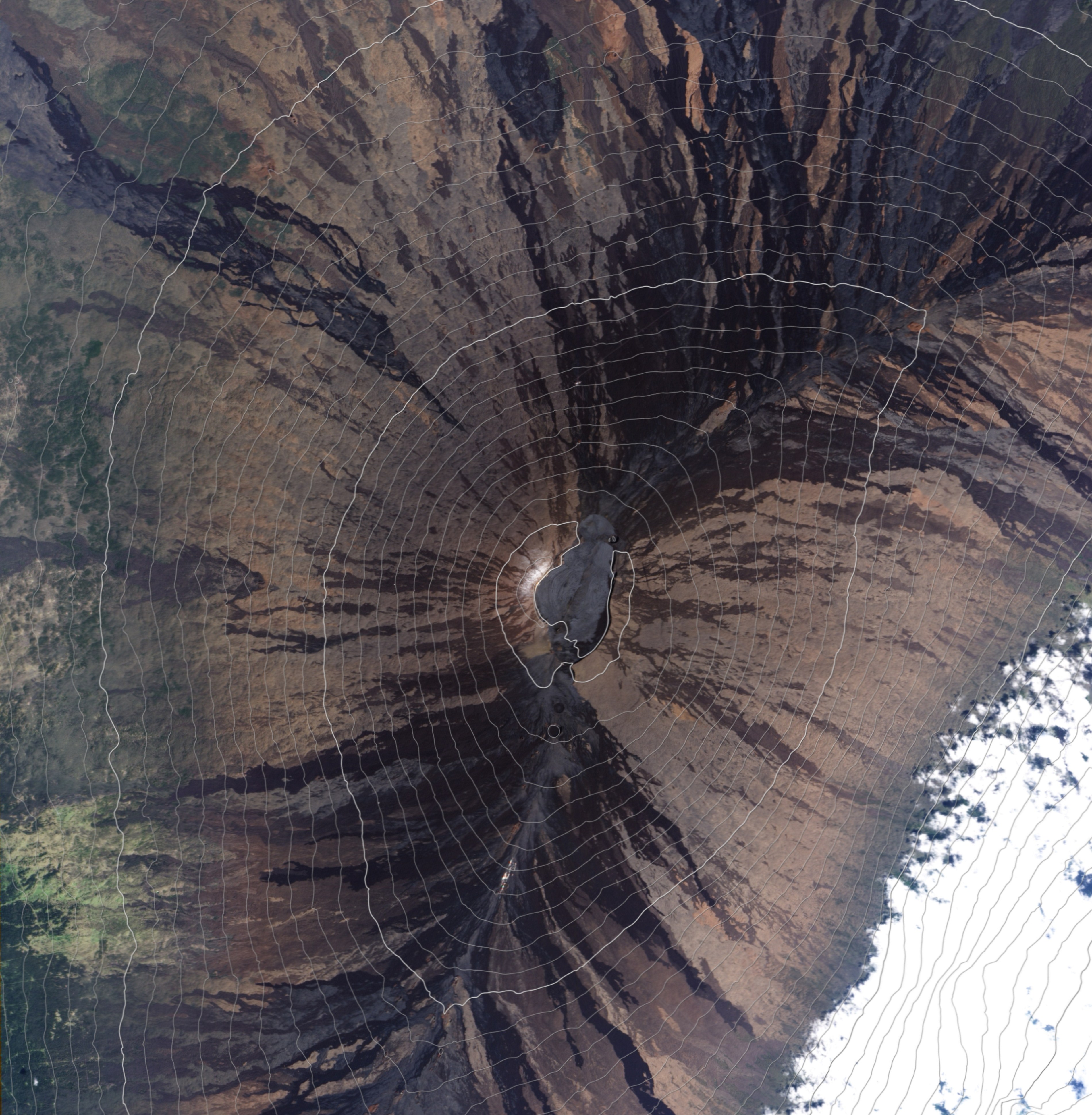 This natural-colour satellite image of the summit of Mauna Loa — overlaid with 100-meter contour lines, helps illustrate why volcanic emissions from the summit rarely reach the observatory. 
The observatory is located on the northern slope of the mountain, 6 kilometres away from and 800 meters lower than the summit.
Most of the time, the prevailing north-easterly trade winds prevent volcanically contaminated air from reaching the observatory. Only on a small percentage of nights do the winds become light and southerly, pushing volcanic emissions downhill to the observatory.