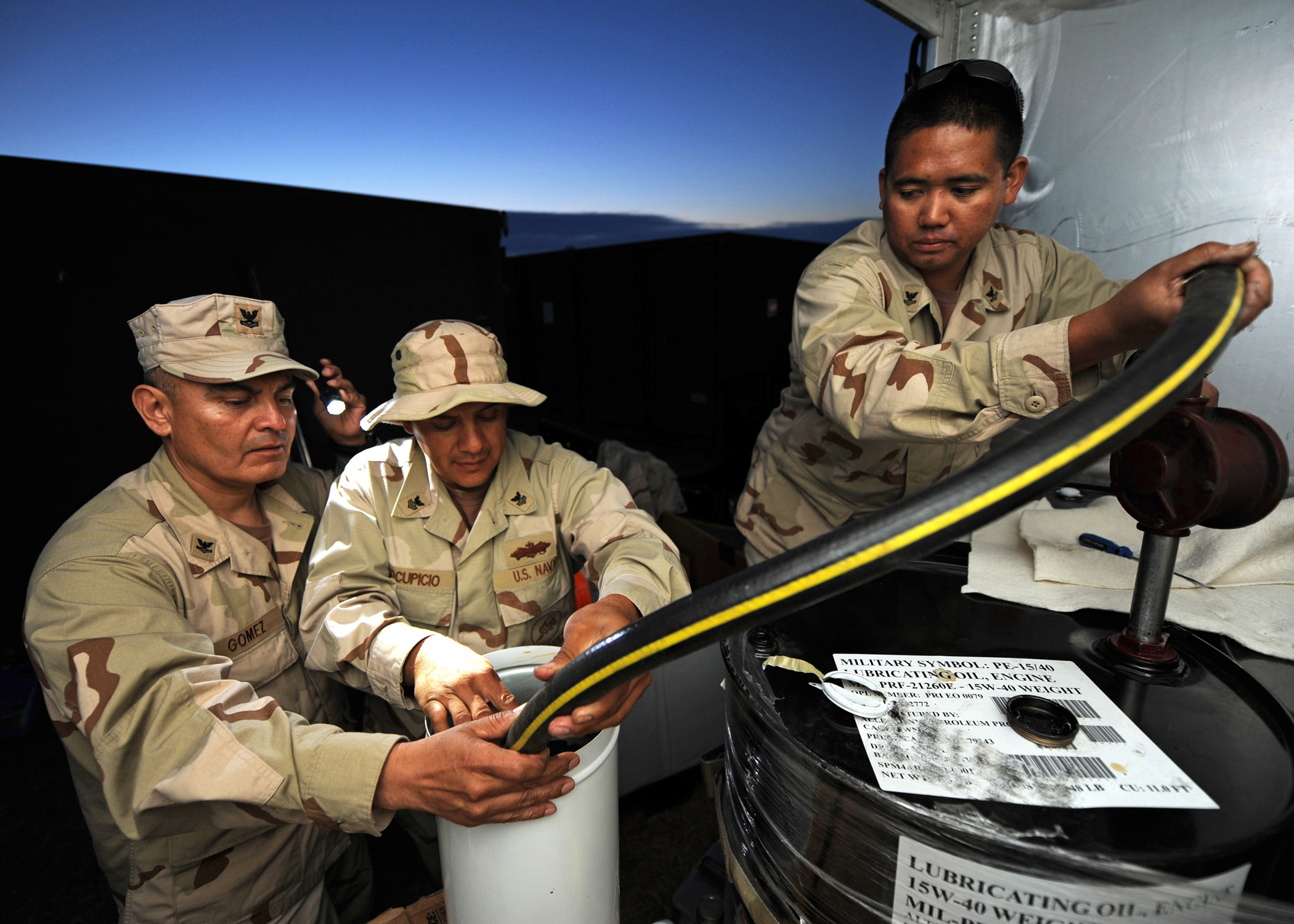 SAN CLEMENTE ISLAND, Calif. (June 4, 2011) Gunner’s Mate 2nd Class Eddiemike Gomez, left, Constructionman Electrician 1st Class Isreal Yocopicio and Electrician’s Mate 2nd Class Romer Ramos, assigned to Maritime Expeditionary Security Squadron (MSRON) 1, pump lube oil for their camp generator. MSRONs-1 and 11 are taking part in the month-long exercise, Shark Tank 2011, which focuses on multi-phase expeditionary squadron level training and certifications. (U.S. Navy photo by Mass Communication Specialist 2nd Class Arif Patani/Released) 110604-N-PM781-069