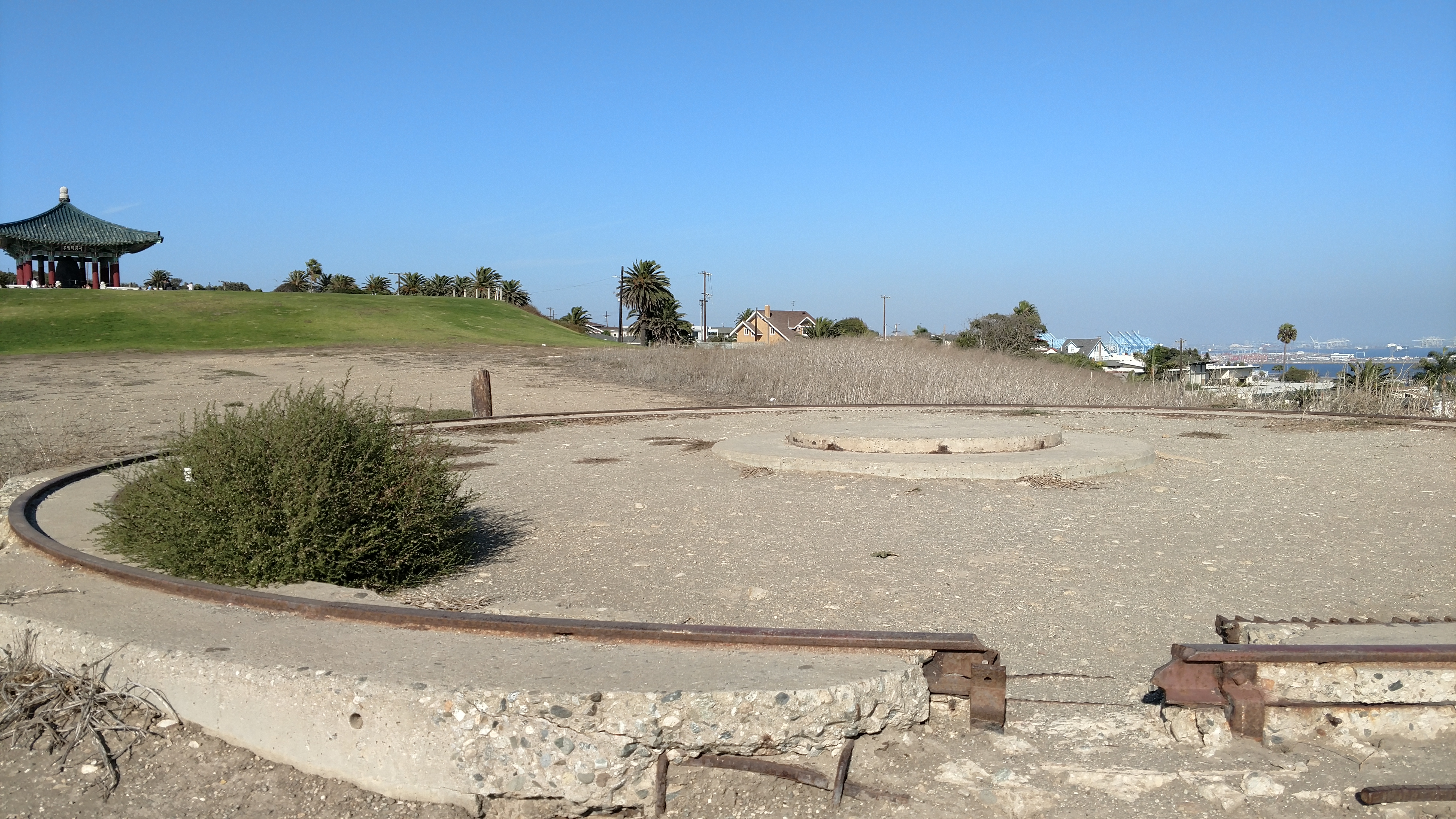 A gun battery emplacement, just west of Battery 241 (beneath the Korean Bell of Friendship, seen in upper left), is still recognizable more than 60 years after its removal at the former Fort MacArthur military base in San Pedro, CA. The fort's Upper Reservation is now managed by the City of Los Angeles Department of Recreation and Parks as Angels Gate Park.