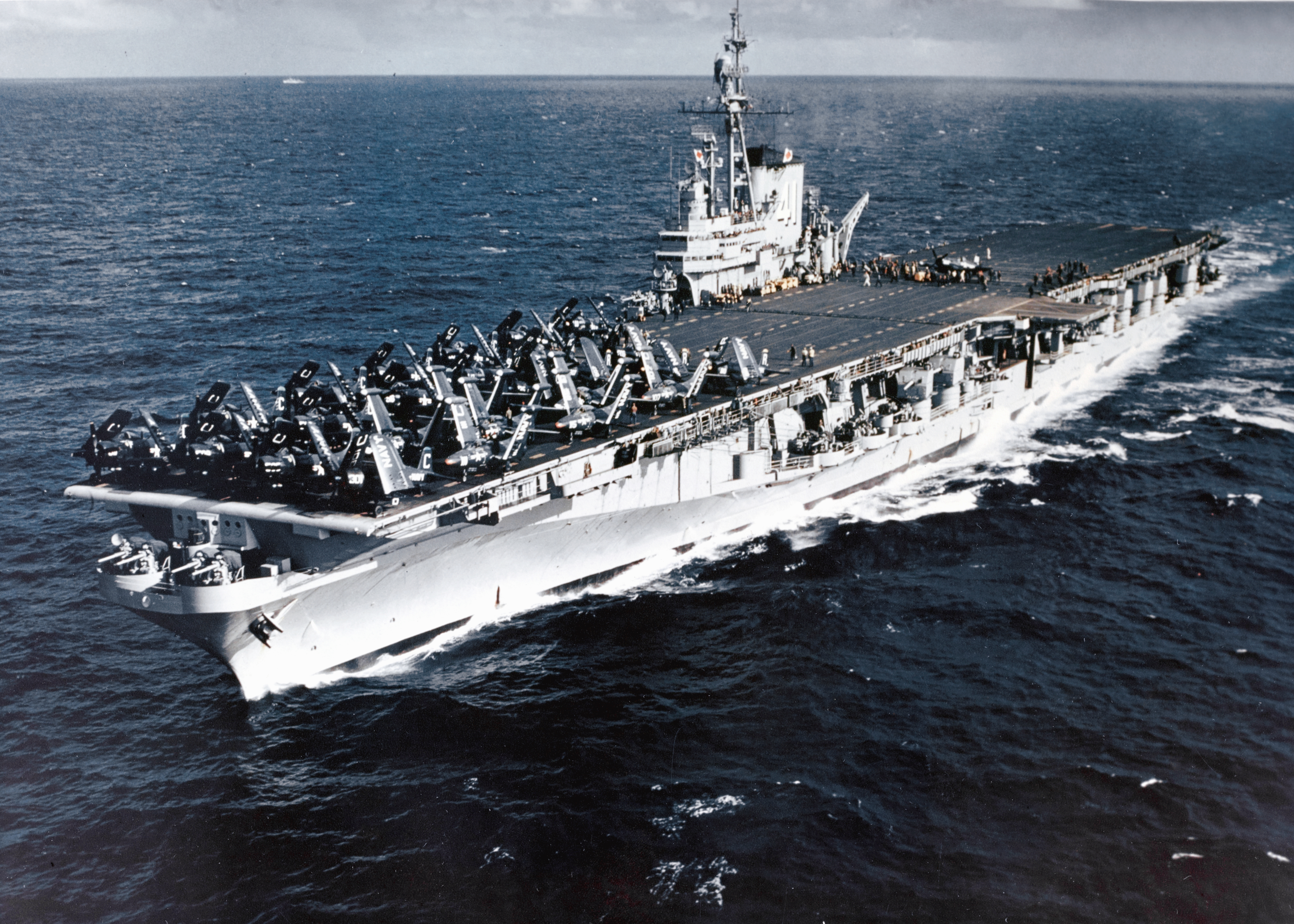 The U.S. Navy aircraft carrier USS Midway (CVB-41) steaming off the Firth of Clyde, Scotland (UK), prior to "Operation Mainbrace" exercises, September 1952. Douglas AD-4 Skyraider, Vought F4U-4 Corsair, and Grumman F9F-2 Panther aircraft from Carrier Air Group 6 (CVG-6) are spotted on her flight deck.