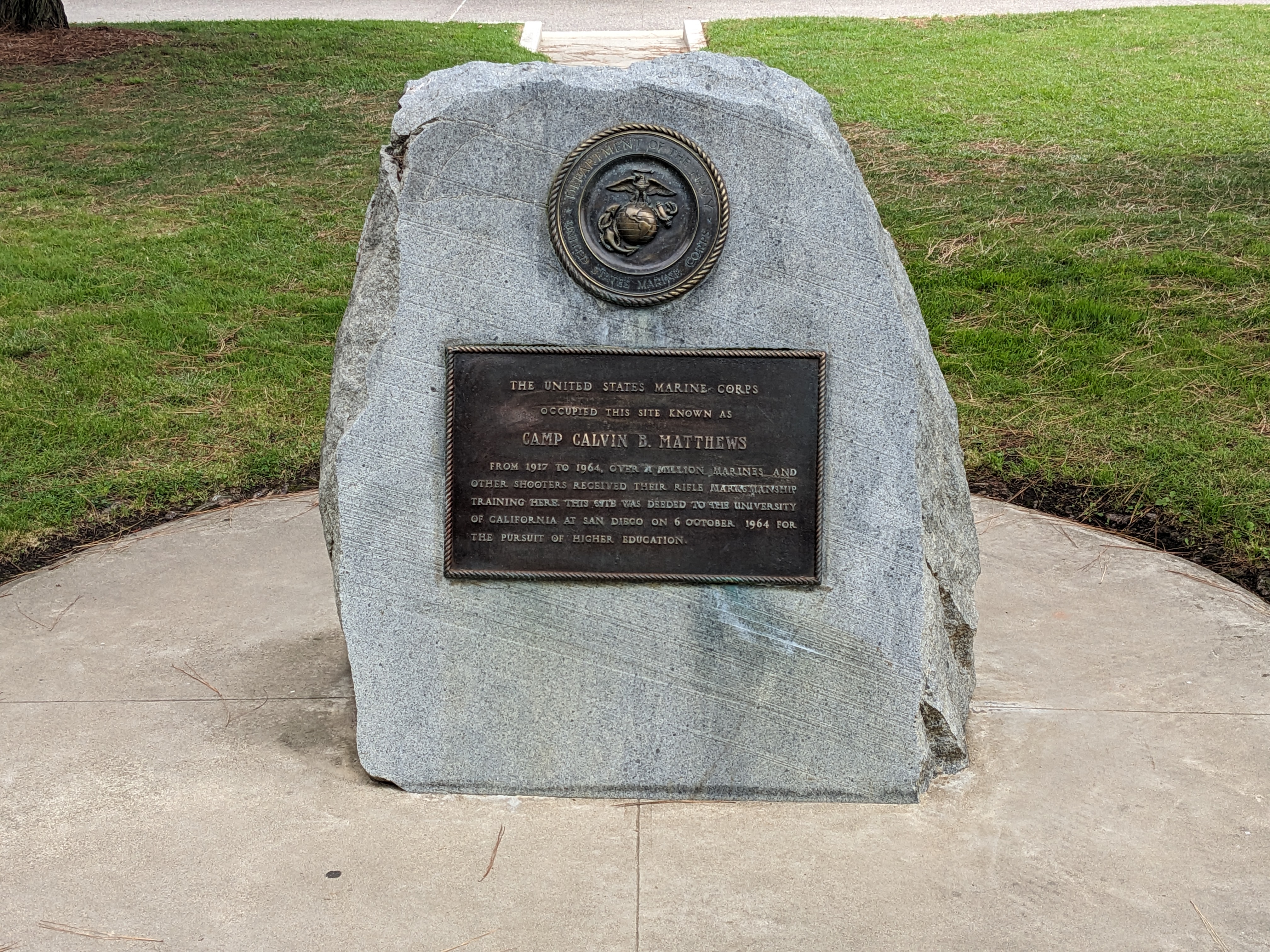 A sign on a slab of rock commemorating Camp Matthews. Town Square, UC San Diego