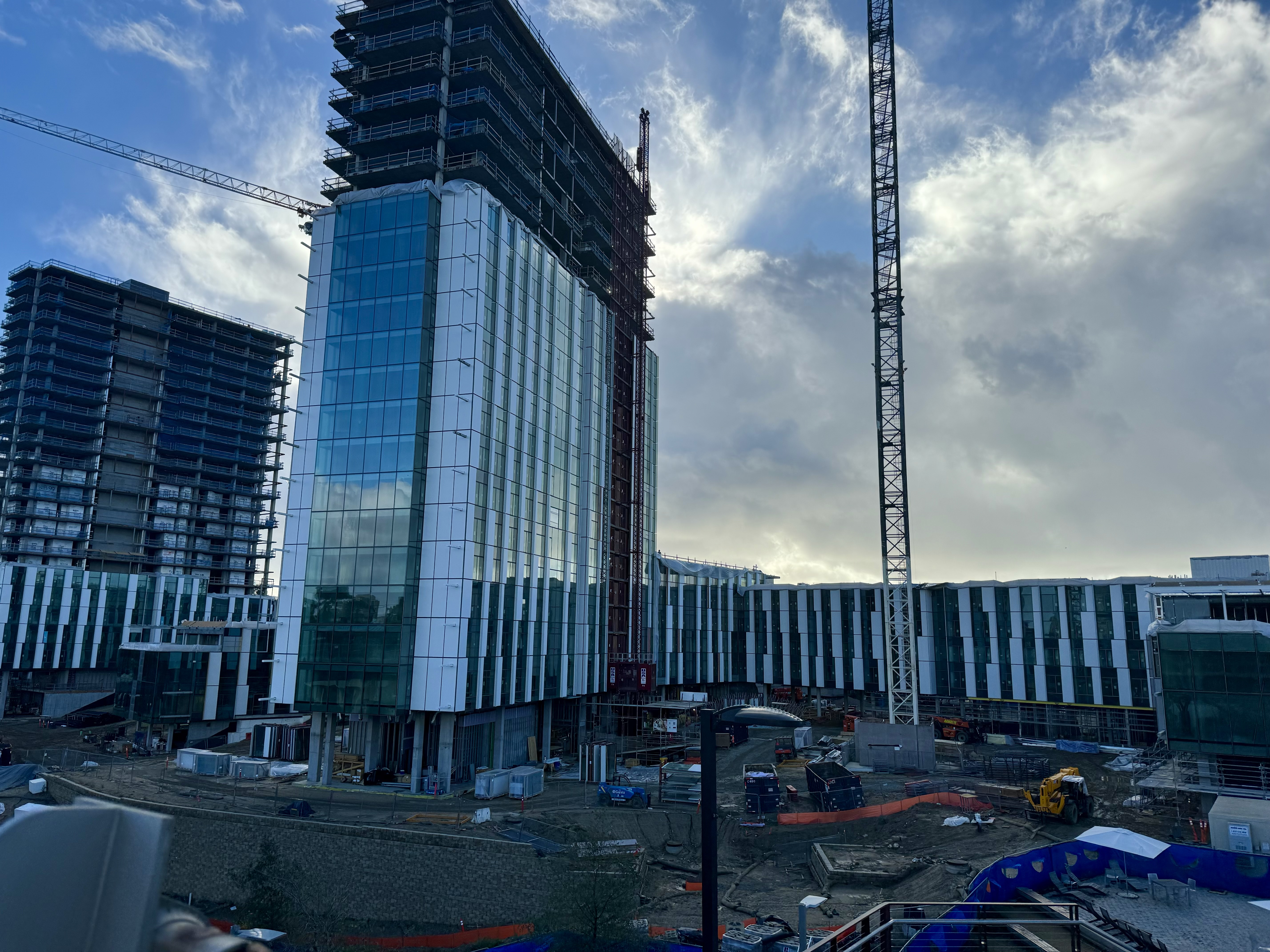 Image of construction at Pepper Canyon West Living &amp; Learning Neighborhood at UC San Diego, as taken from the UC San Diego Central Campus Station. Both the Vela and Rya buildings are visible, and are at different stages of construction.