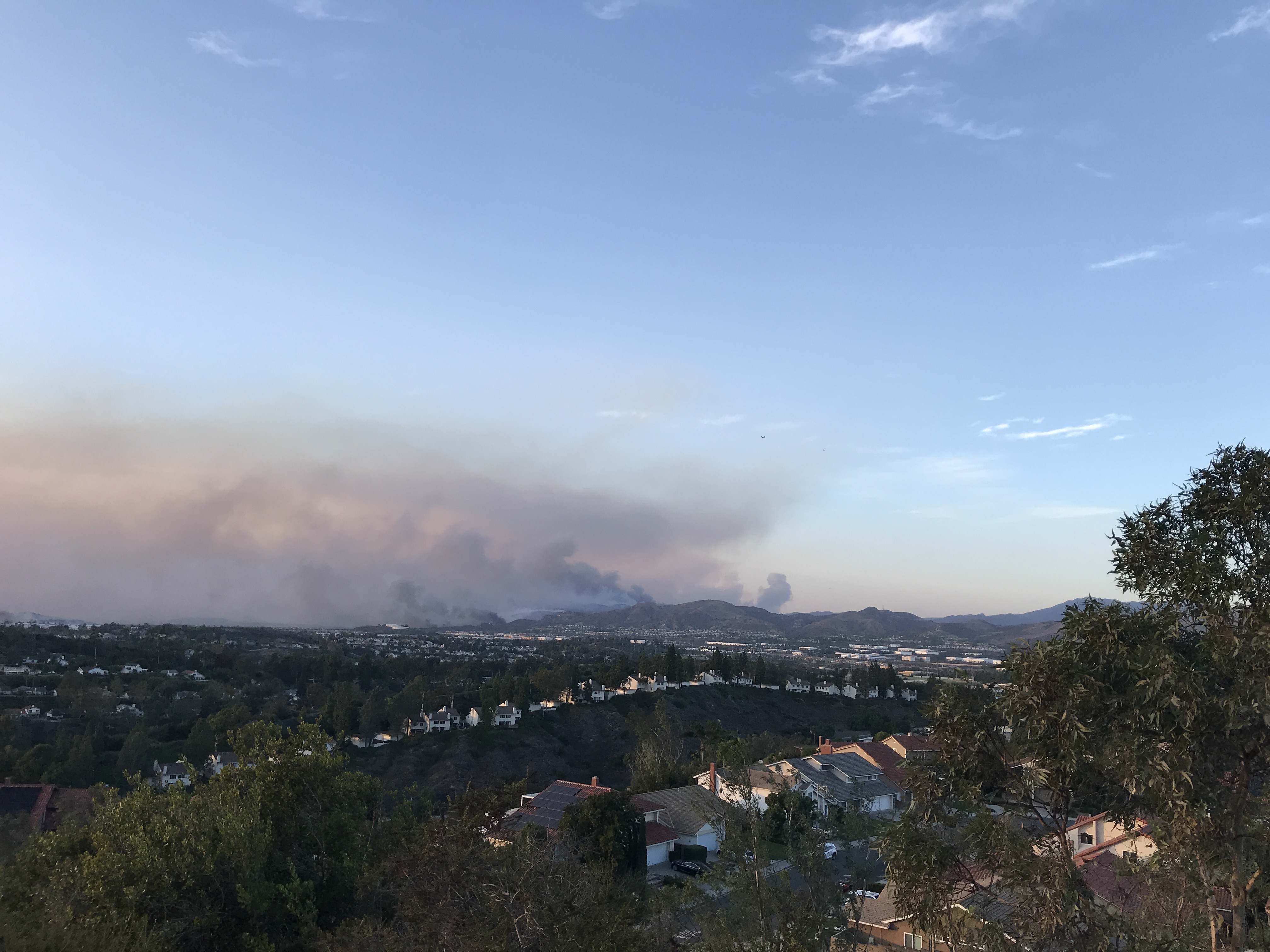 Image of the Silverado Fire roughly 12 hours after it had initially started. Flames can be seen in the image and the smoke is being pushed out towards the ocean due to high Santa Ana Winds. Image was taken along Vista del Largo trail in nearby Mission Viejo, California where some homes were had voluntary evacuations.
