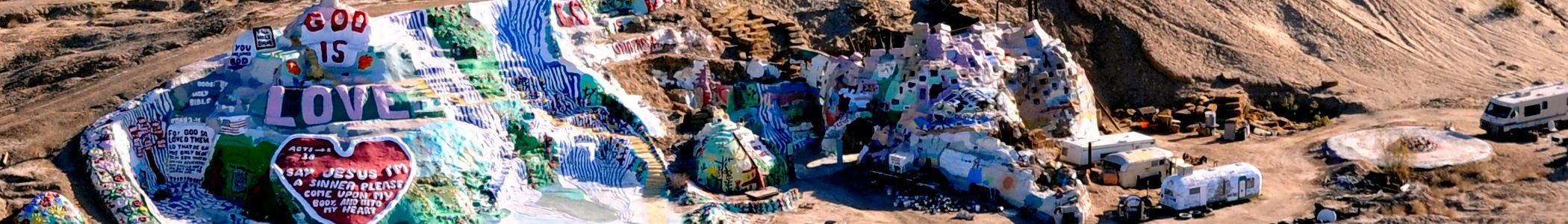 Shows a birds-eye view of Salvation Mountain in Slab City, CA