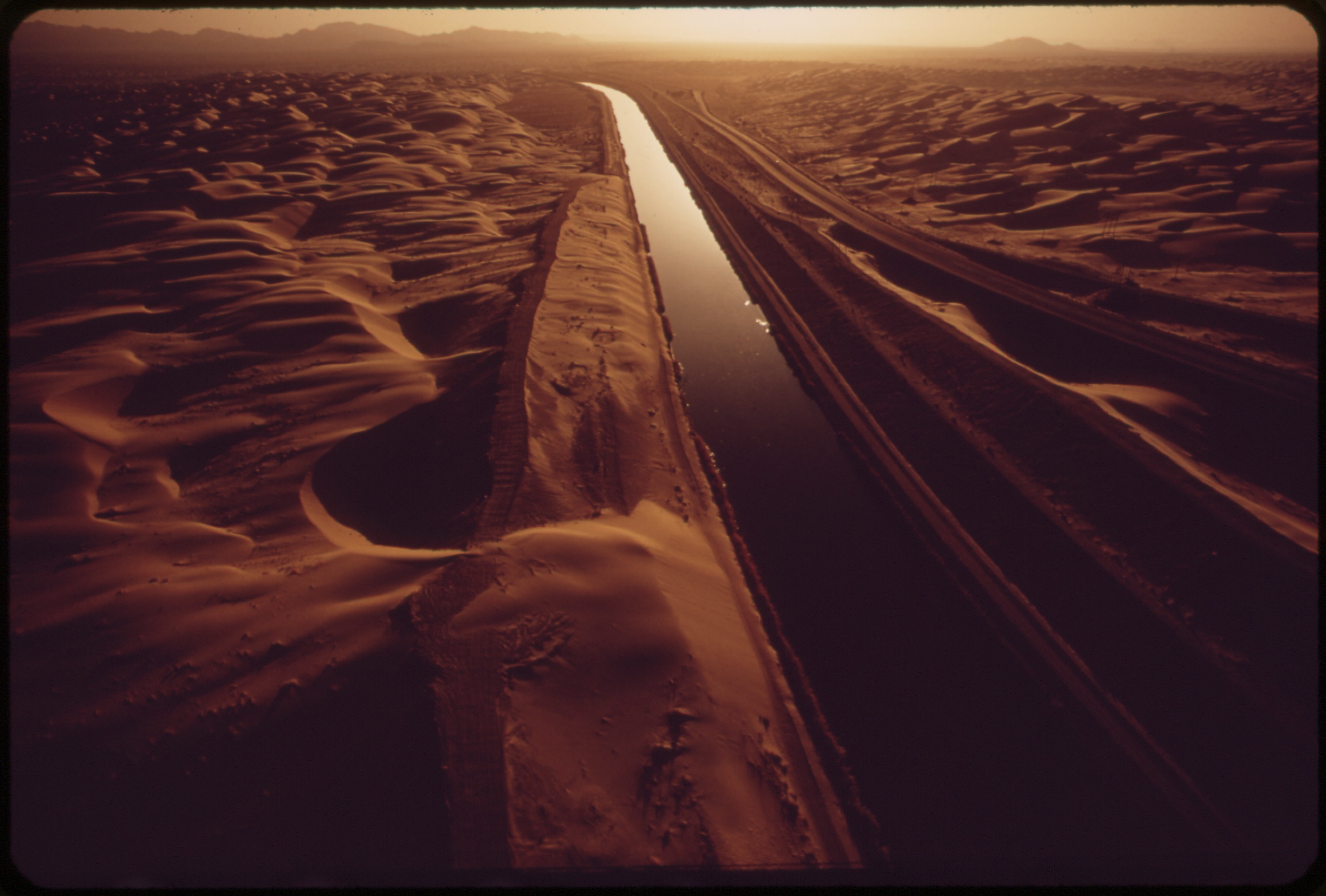 ALL-AMERICAN CANAL CARRIES COLORADO RIVER WATER THROUGH SAND-SWEPT AREA OF THE IMPERIAL VALLEY - NARA - 549076.jpg