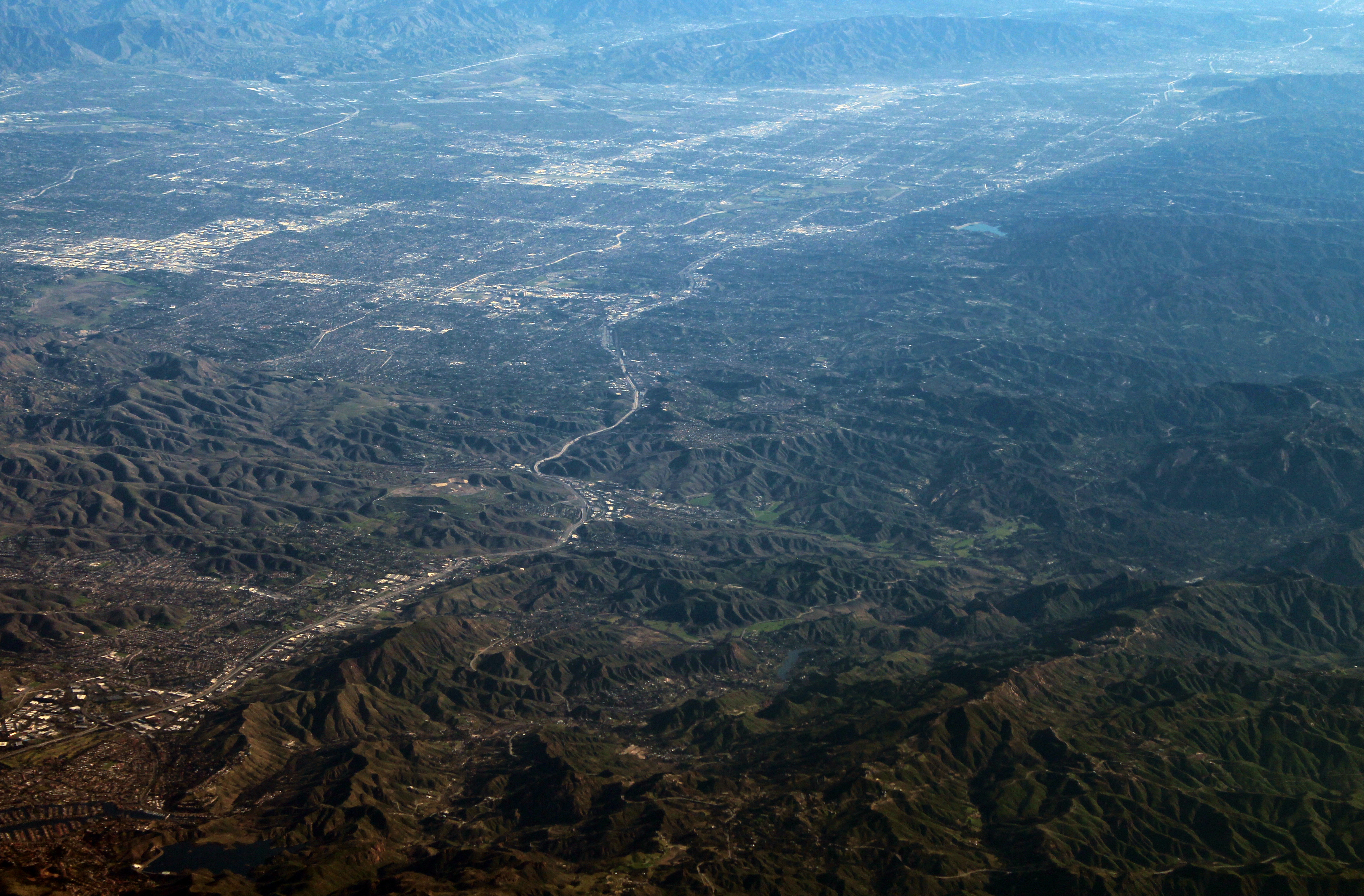 Aerial view of Calabasas and the San Fernando Valley, facing northeast from a passing jetliner off the coast of Oxnard (which had just departed from John Wayne Airport).  This image has been balanced to compensate for haze and smog. 
Photographed by user Coolcaesar on February 2, 2020.