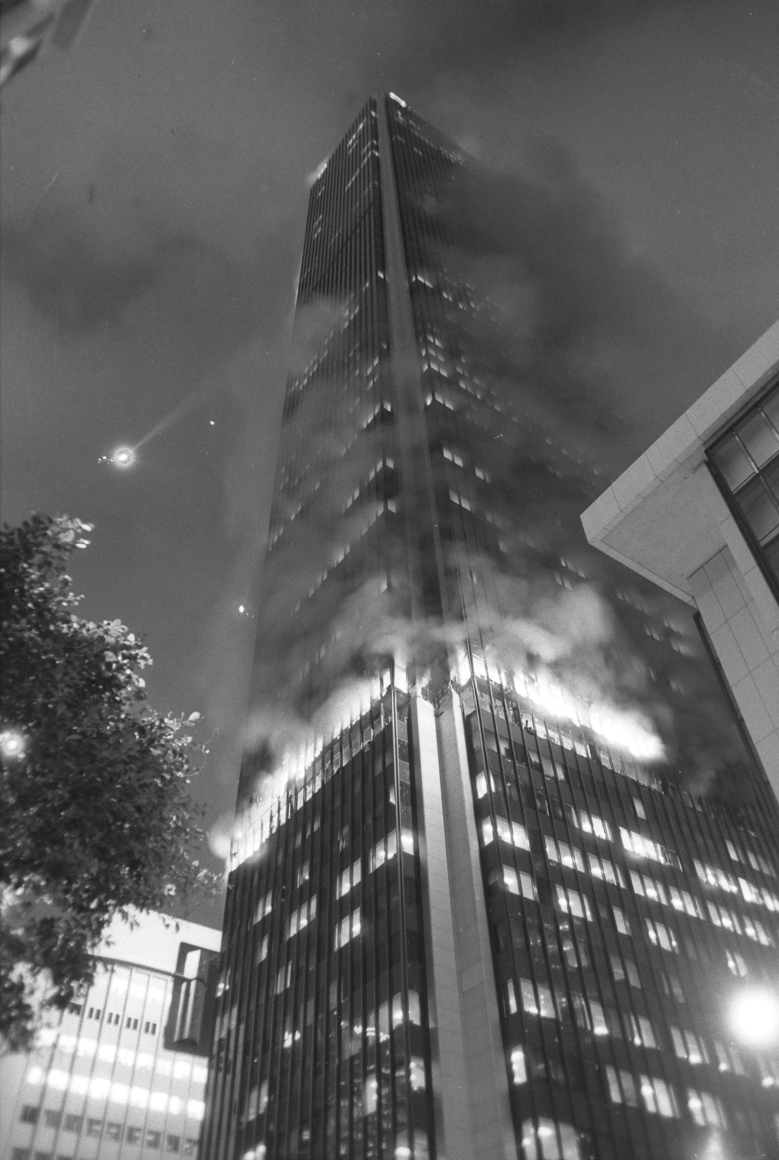 Flames and smoke pour out windows of First Interstate Bank Building in downtown Los Angeles.