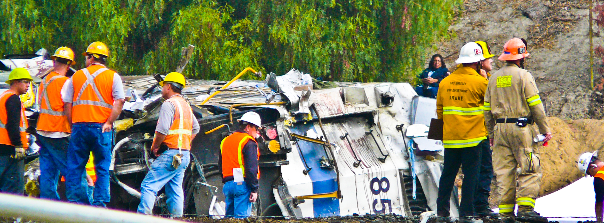 Recovery workers flank the rear of the Metrolink locomotive after it was removed from the lead passenger car, where most of the serious injuries and death occurred.