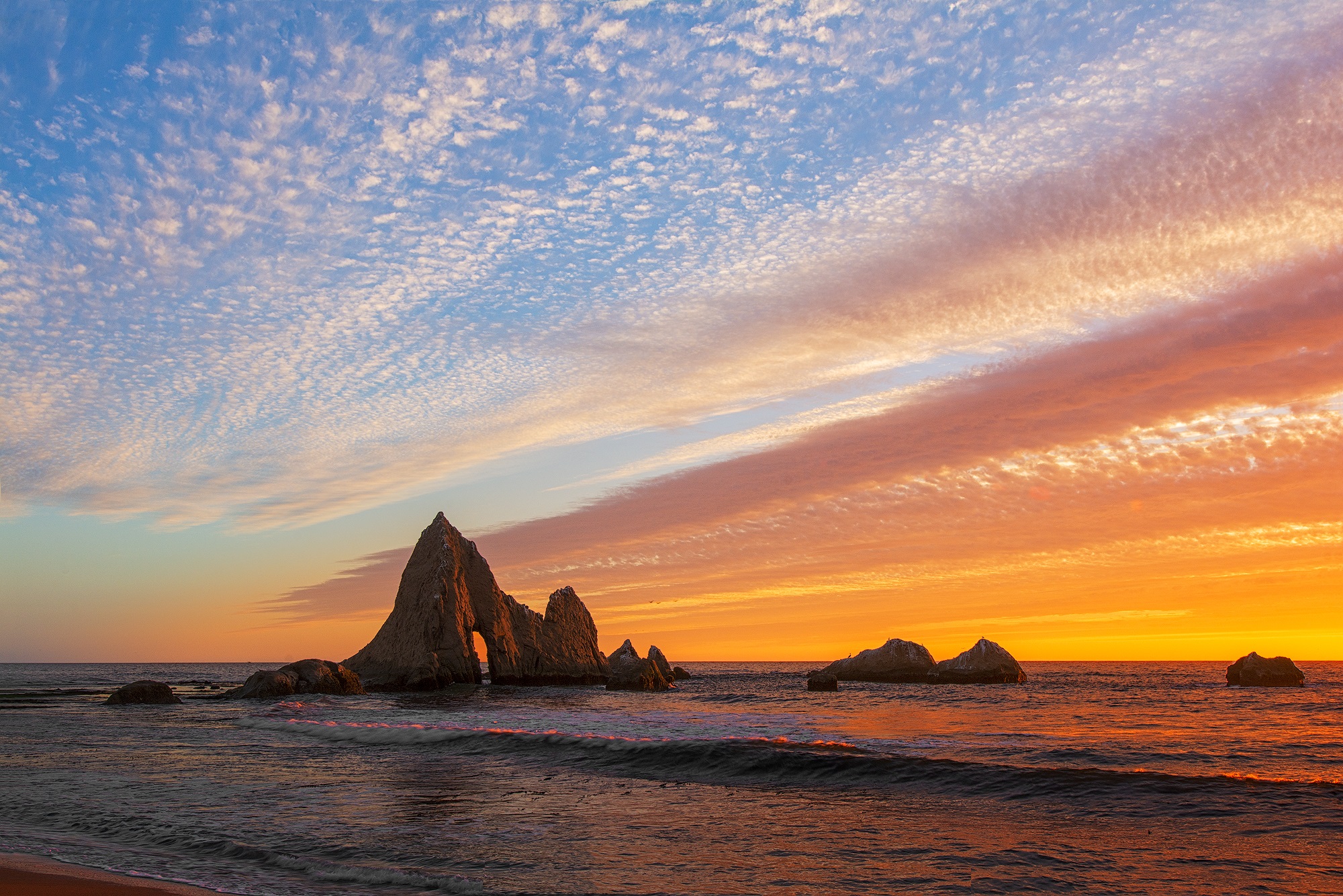 Martin's Beach, Half Moon Bay, CA
Here is a still picture from my timelapse taken from 9/14/2018. I like to the cloud shape matched to the arch rock, and the lights on the seastack, as well as water.

Sunset Burn was predicted by Yiupai Sunrise/Sunset Forecast Service.