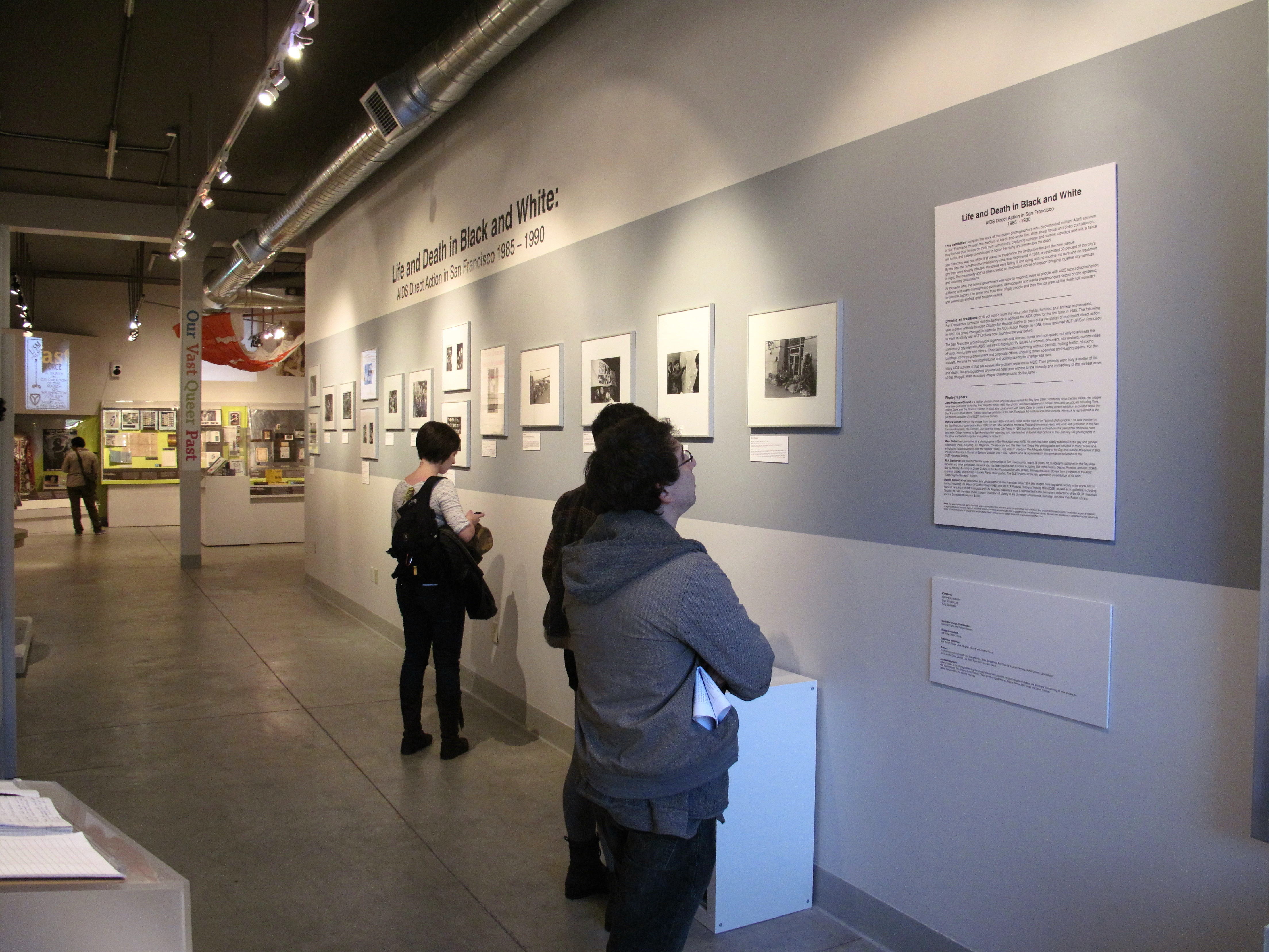 Visitors to the Main Gallery of The GLBT History Museum in San Francisco view "Life and Death in Black and White: AIDS Direct Action in San Francisco, 1985–1990," an exhibition of photography open March 2012 through July 2012.