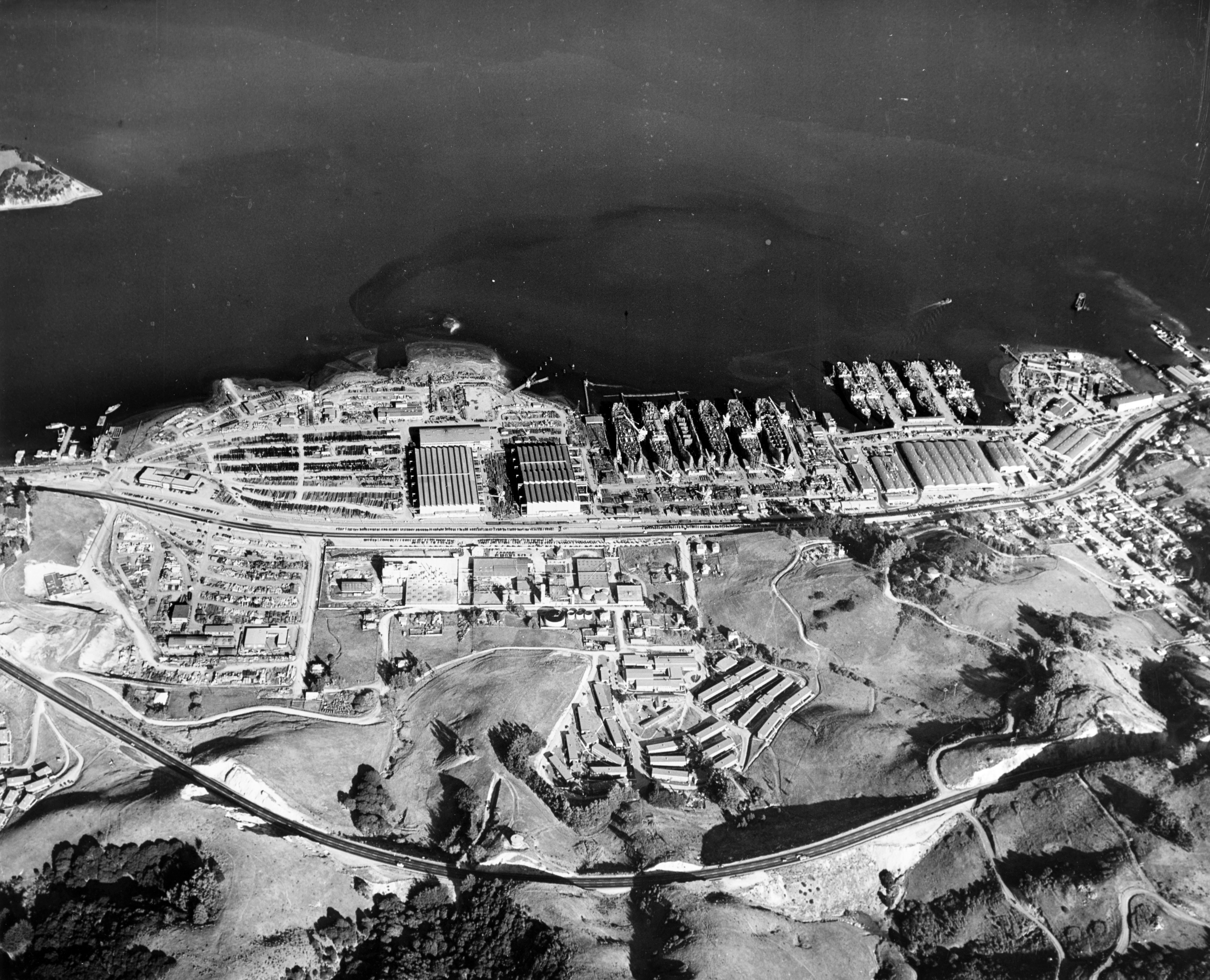 Aerial view of the Marinship Corporation shipyard, Sausalito, California (USA), looking east, 6 December 1944. Marinship Corporation was an emergency yard, built by Bechtel-McCone with 6 ways in the fifth wave of shipbuilding expansion funded by $17 million from the U.S. Marine Corps. It was one of the four yards that built T-2 tankers. Marinship was remarkable for laying its first keel within three months of receiving authorization to build the shipyard. At its peak, Marinship employed 20,000 people. After the Second World War, the yard was taken over by the U.S. Army Corps of Engineers and redeveloped.