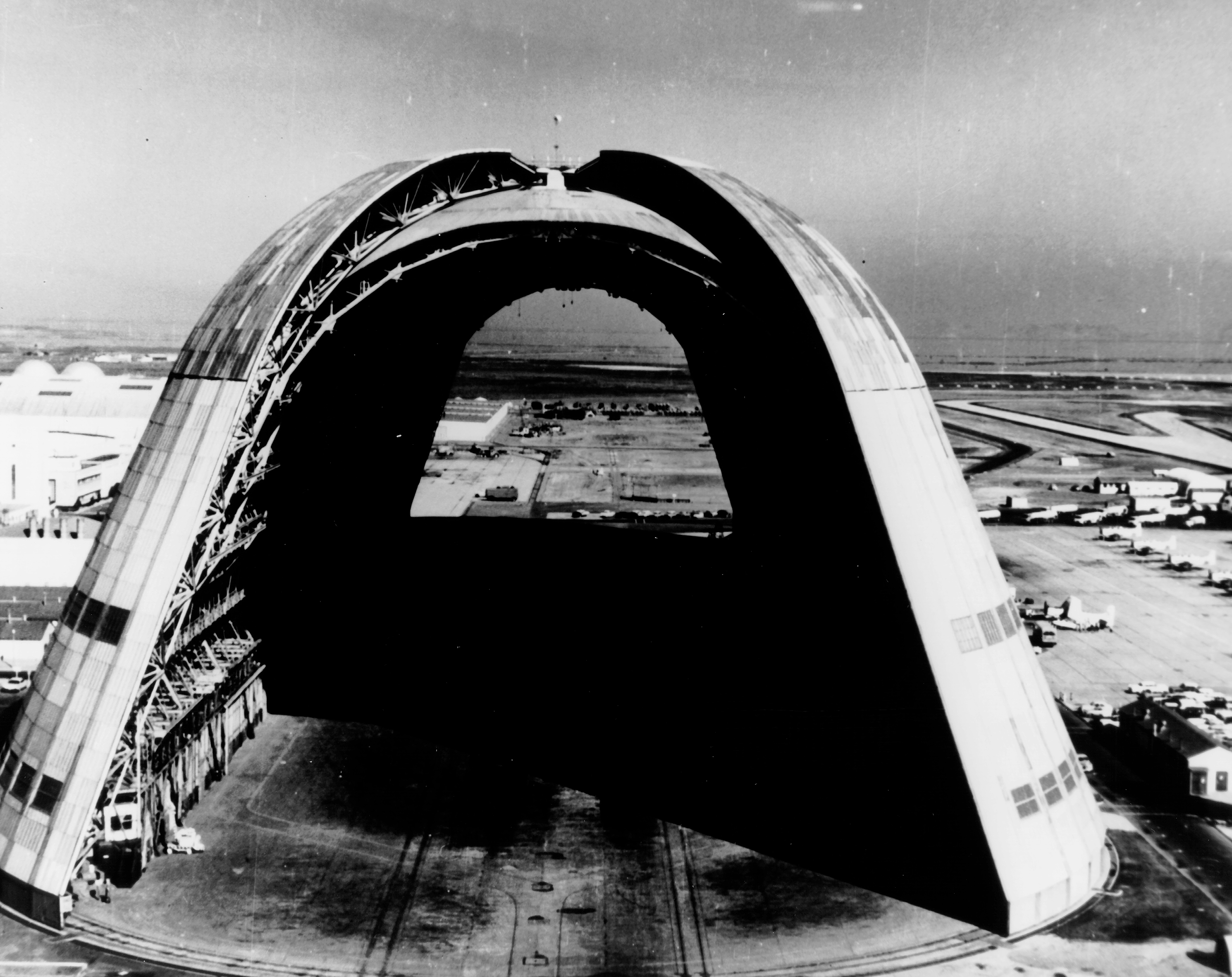 This is a view of the huge dirigible hangar with doors open at both ends at the NASA Ames Research Center, Moffett Field, California. Lockheed Missiles and Space Company under contract to the NASA-Marshall Space Flight Center was to use the hangar for construction and assembly of the nation's first nuclear stage rocket engine.
Airplanes are on the ground at right, and in the background is San Francisco Bay. The ready-made "factory" structure was erected in 1931-1933, to house the dirigible Macon, which crashed off the California coast in 1935. It has been used by the Navy for blimps and aircraft. 

The floor area 1,138 feet by 308 feet, covers over eight acres or enough to hold seven football fields. The height of the hangar is 198 feet, ample for the company to erect the RIET (Reactor-In-Flight Test) stage in an upright position. The program was eventually canceled.