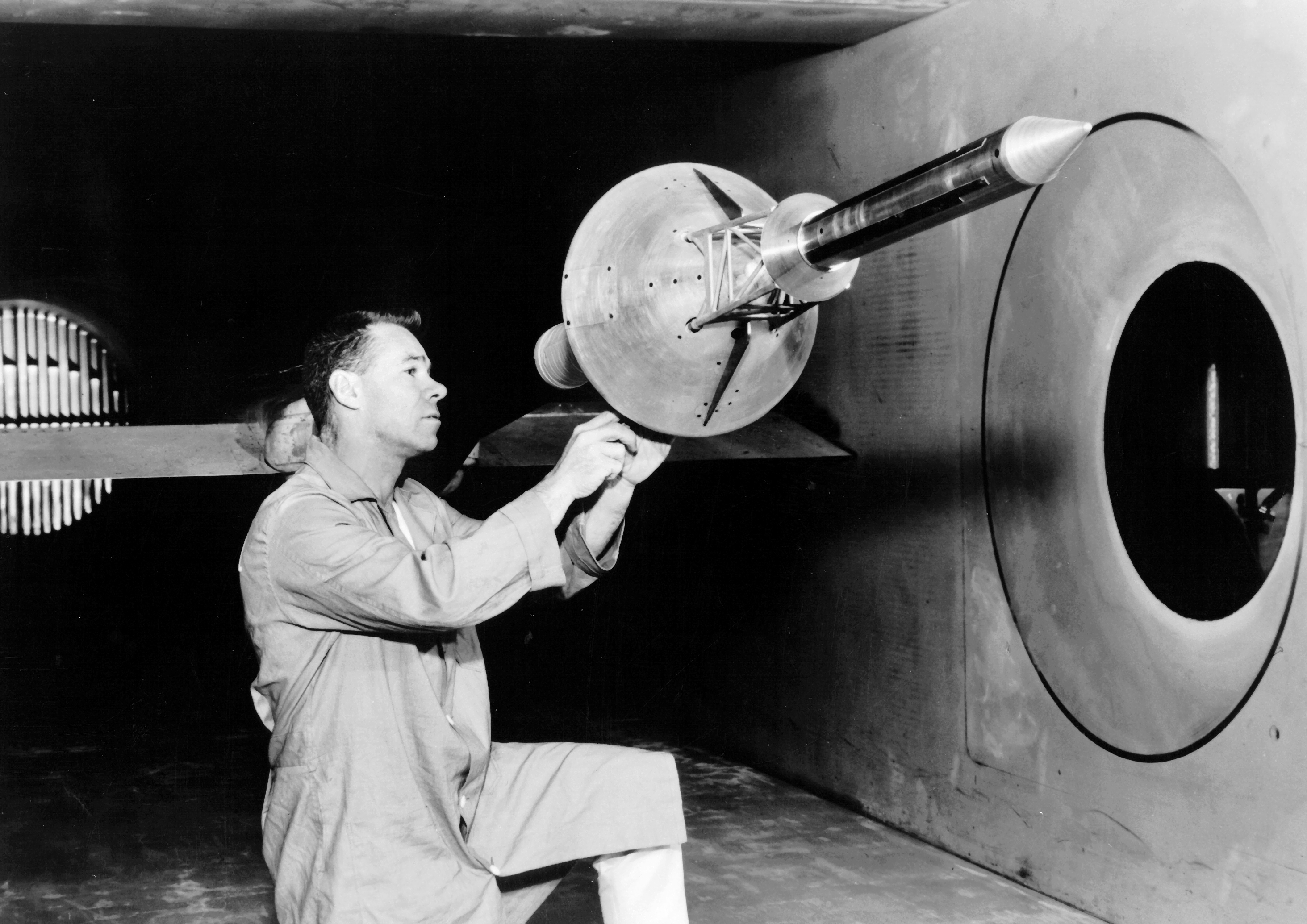 A technician mounts a model of the Apollo Launch Escape System (LES) in the Unitary Wind Tunnel at the NASA Ames Research Center, Moffett Field, California. The LES was a tower like structure consisting of four solid propellent motors mounted atop the Apollo Command Module. In the event of a contingency, (booster failure or some other imminent failure) the LES would be commanded to ignite, subsequently removing the Command Module from the Saturn launch vehicle.