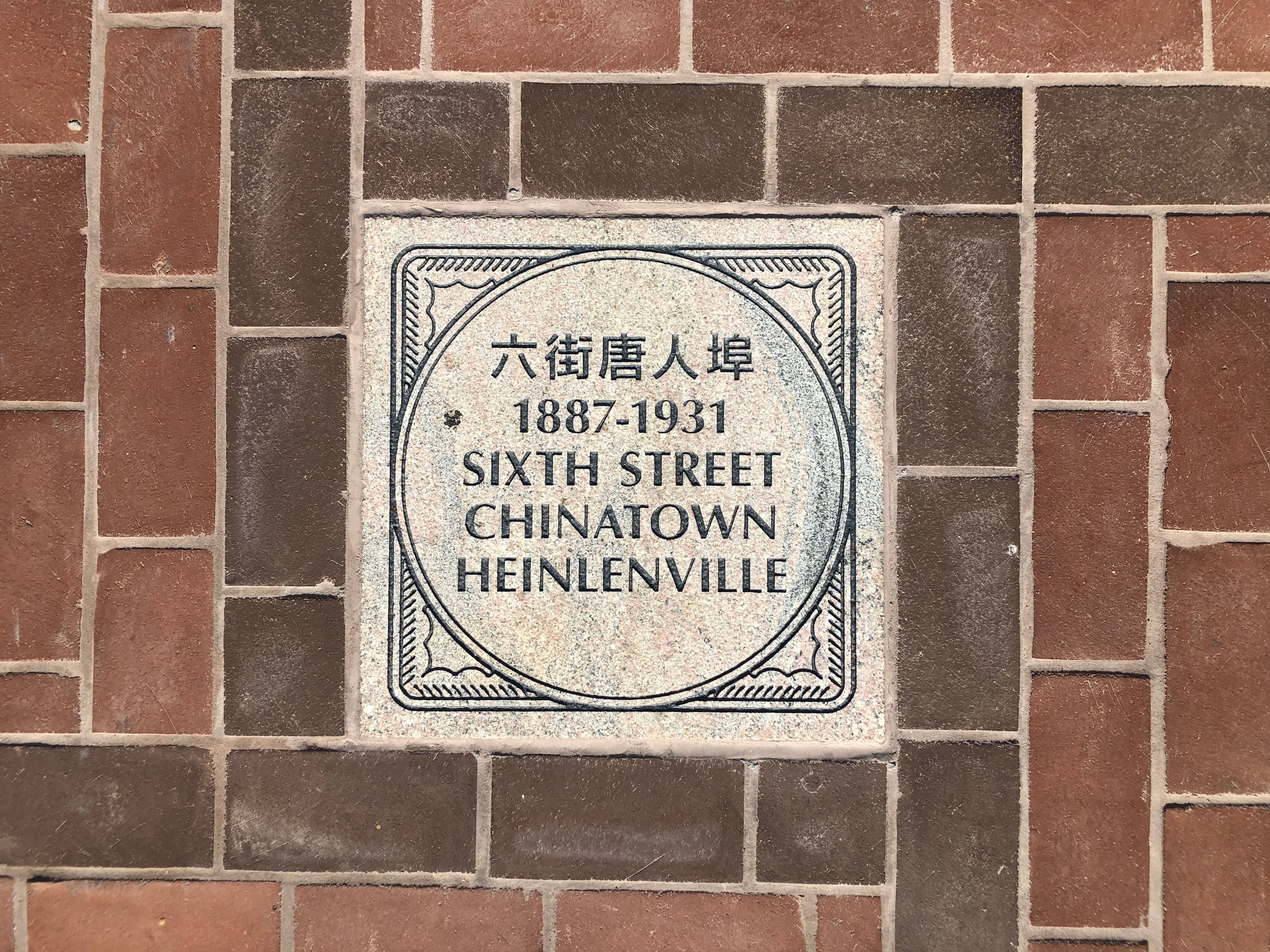 A stone “floor medallion” commemorates the Sixth Street Chinatown, also known as Heinlenville, on the plaza at Heinlenville Park in San Jose, California.