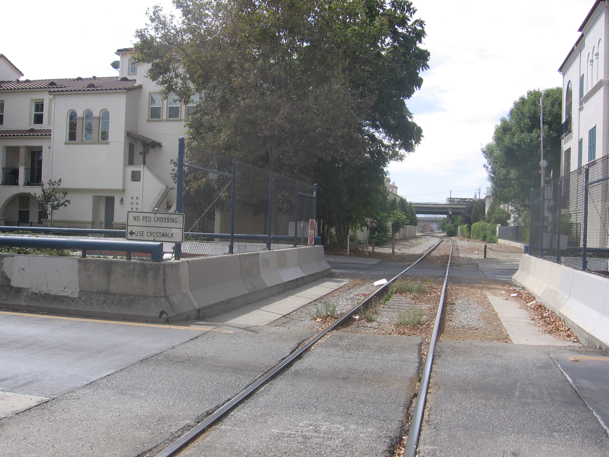 This Union Pacific rail line passes over the VTA trench along North 1st Street in San José, California, USA.  This  rail line is the raison d'être for the trench.  The apartment buildings on the left were built upon the site of the Southern Pacific's Market Street Station (which was torn down in 1935 to make way for what would become known as Diridon Station).