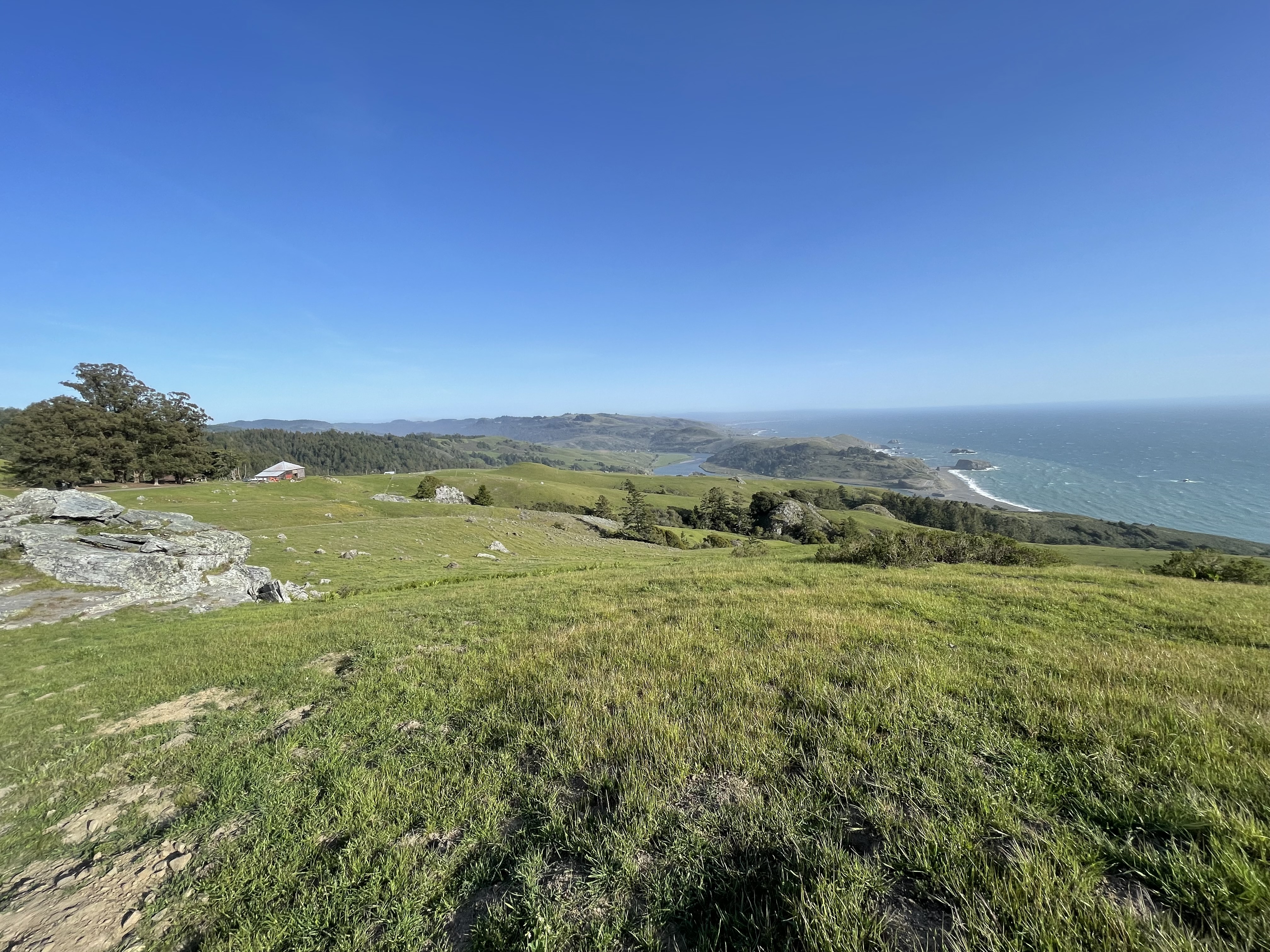 This is coastal prairie descending to Russian River mouth and Pacific Ocean. The view is from The Wildlands Conservancy Jenner Headlands Preserve. The river is a major geographic feature in this region.