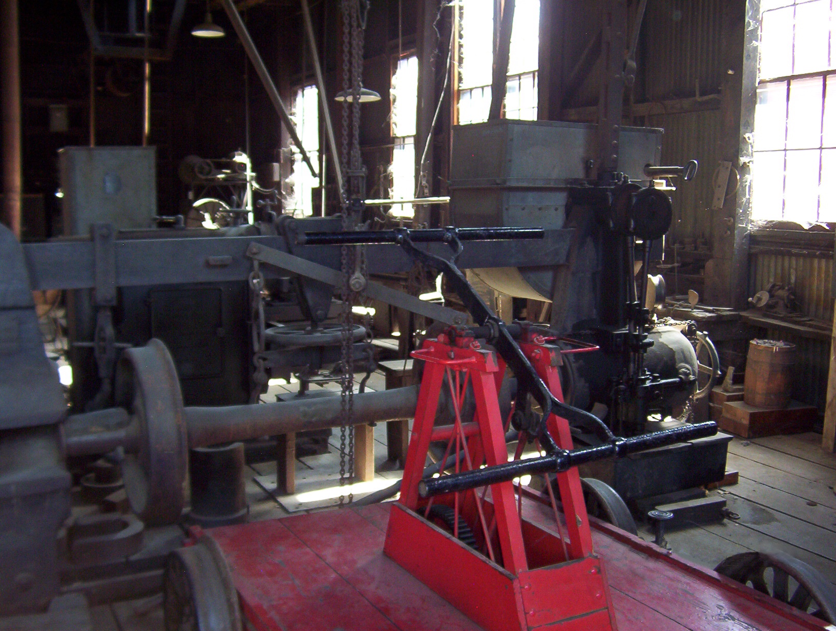 Machine shop, Sierra Railroad (Railtown - 1897), Jamestown, CA.  Wheel press and hand car in foreground.  Shaper and two engine lathes in background.  Machines driven by overhead flat-belt line shaft.