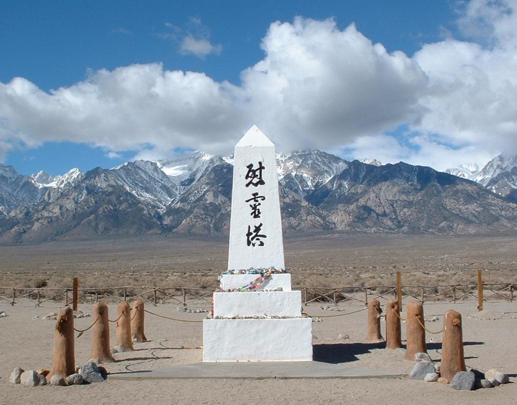 Cemetery shrine, Manzanar Japanese internment camp, Owens Valley, California, looking west toward the Sierra Nevada. The inscription is in Japanese and reads 慰霊塔 (ireitõ), meaning "Monument to console the souls of the dead." The inscription on the back reads "August 1943" and "erected by the Manzanar Japanese." The obelisk shrine currently is draped in strings of origami and has offerings of personal items left by survivors and visitors. The park service periodically itemizes and collects these items in order to gauge the changing feelings of visitors.