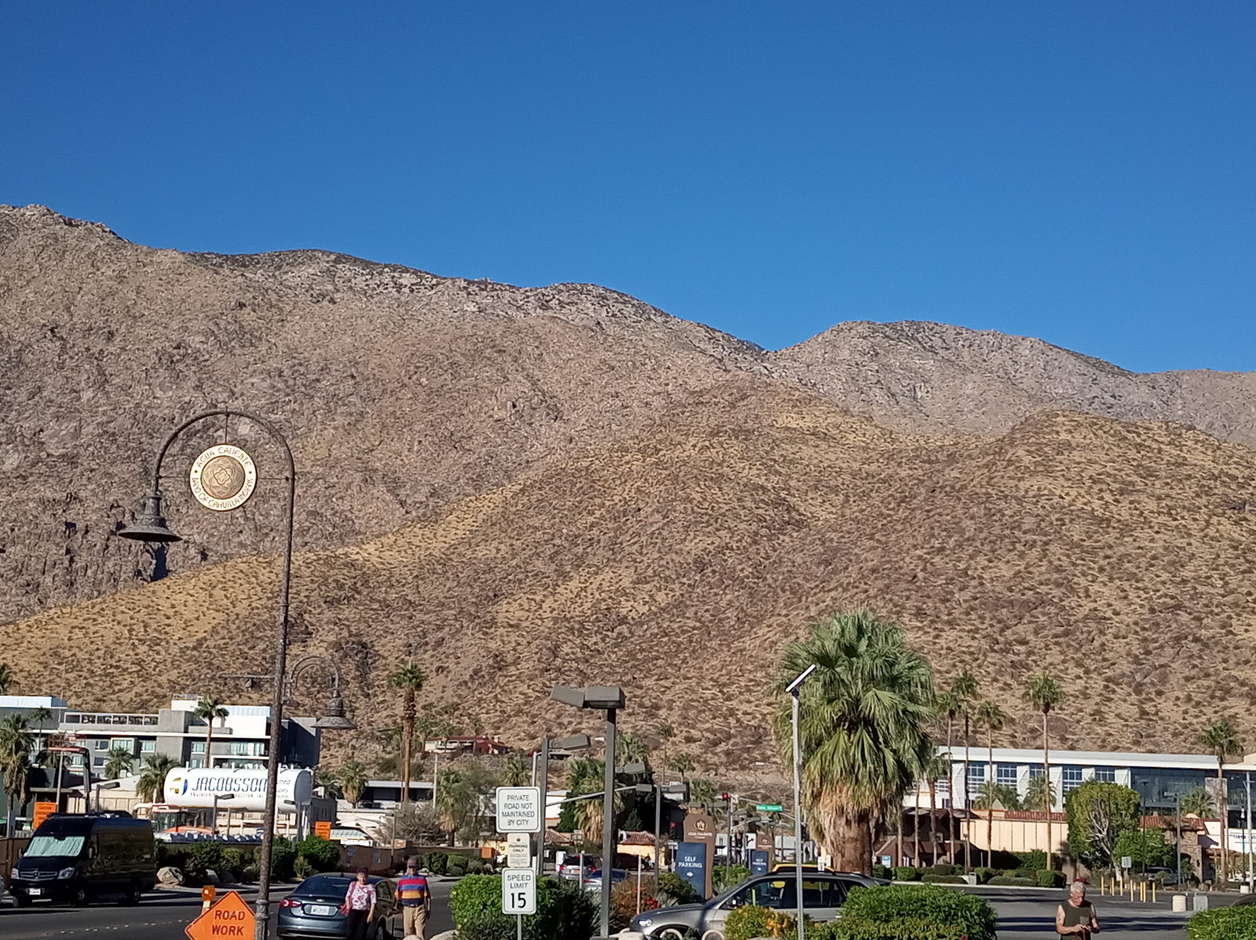 A round sign with the insignia of the Agua Caliente Band of Cahuilla Indians, suspended from a streetlamp post in downtown Palm Springs, California.
