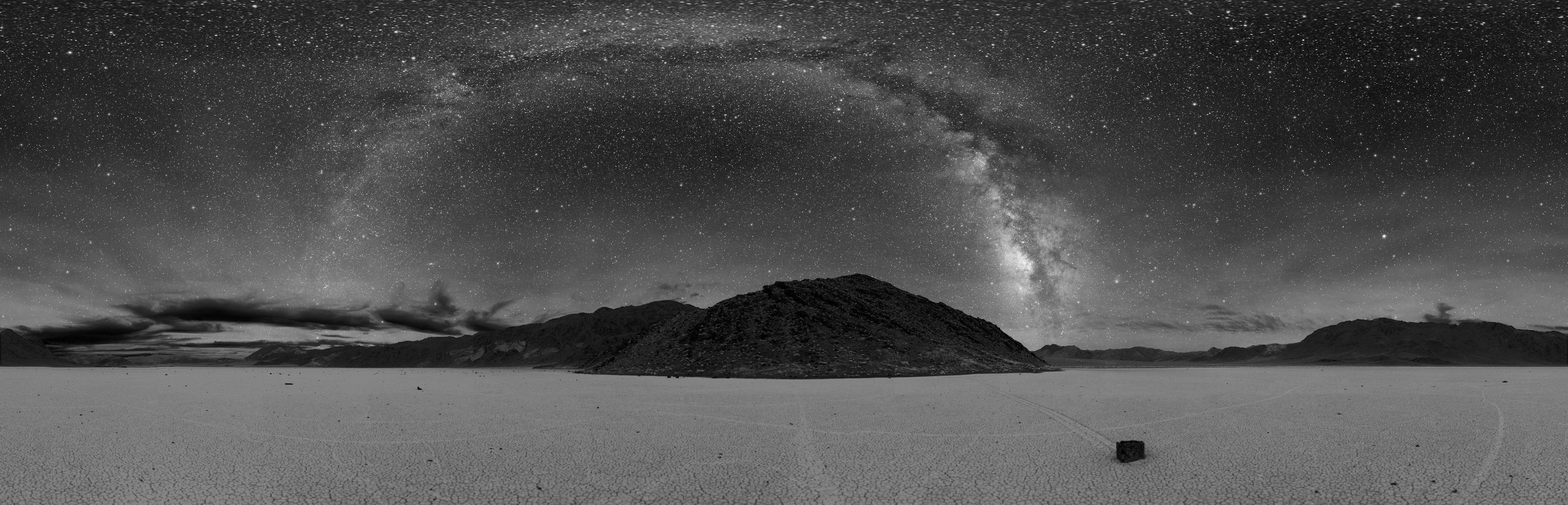 360° panorama of Racetrack Playa in Death Valley at night. The Milky Way is visible as the arc in the center. A sailing stone is also seen below along with the tracks of other stones.