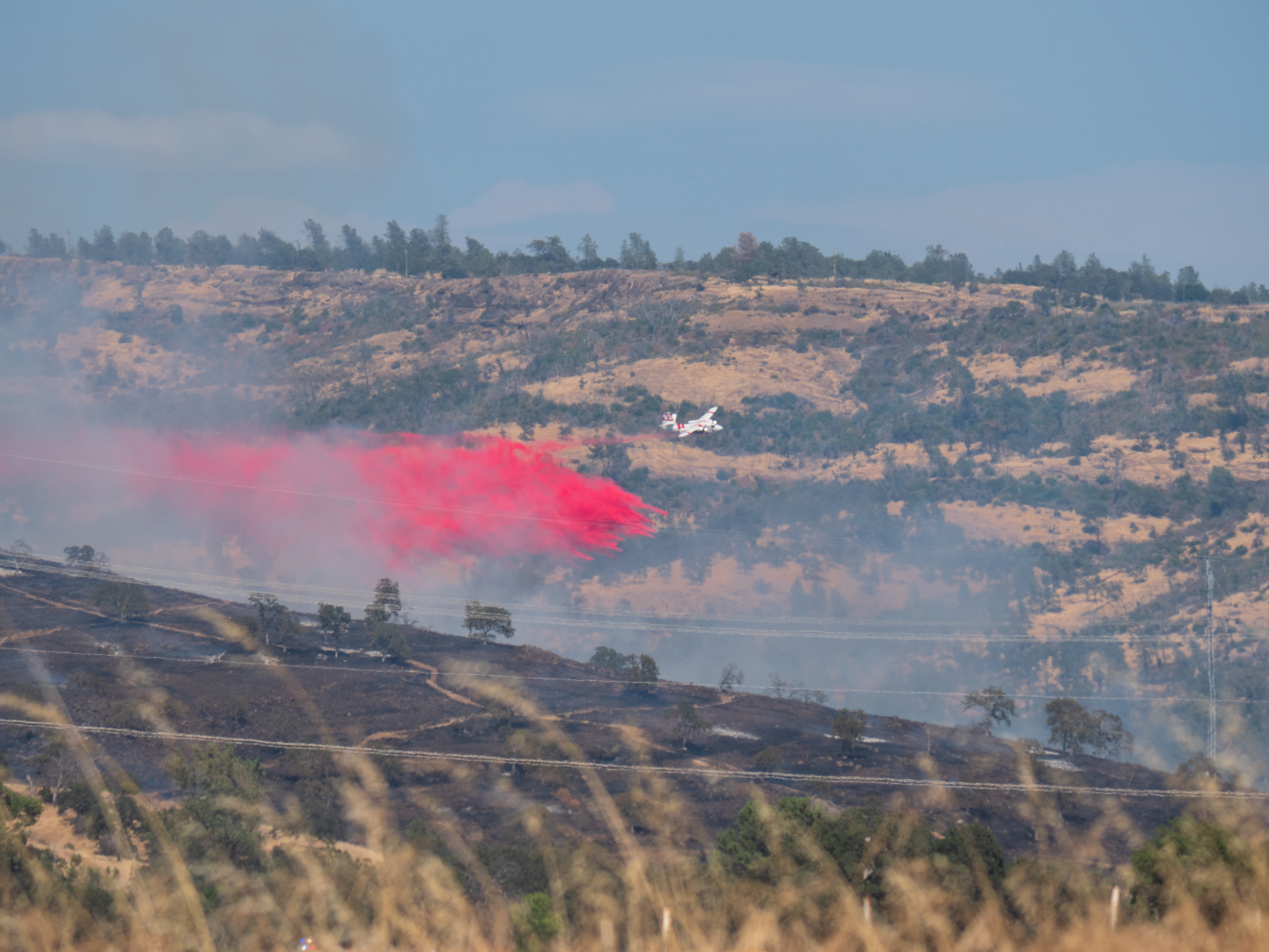 An airtanker engages the advancing front of the Park Fire within Upper Bidwell Park during the early hours of the fire near its point of origin on Wednesday, July 24, 2024.