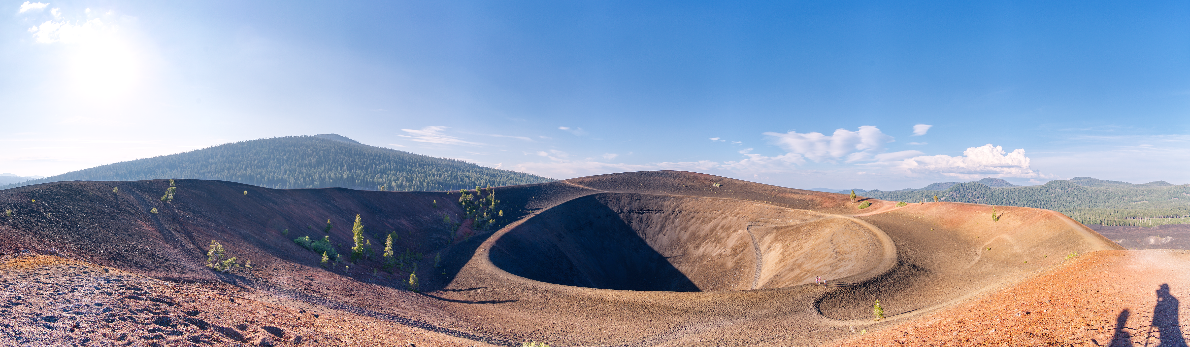 A panoramic view of the caldera at the top of Cinder Cone in Lassen Volcanic National Park. Several trails can be seen going in and out of the cone.