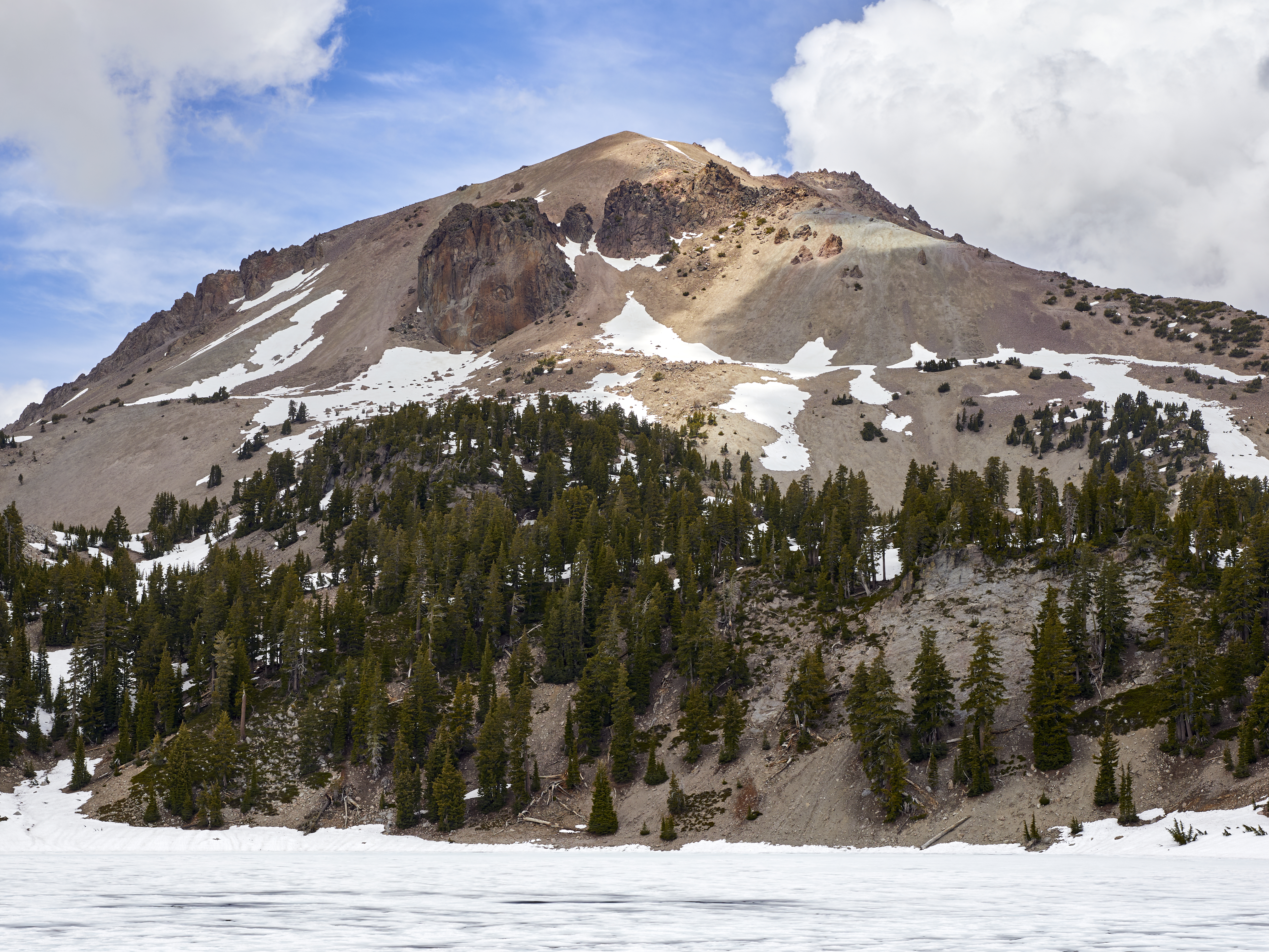 Lassen Peak in Lassen Volcanic National Park as seen from the shore of frozen Lake Helen on June 12, 2020.