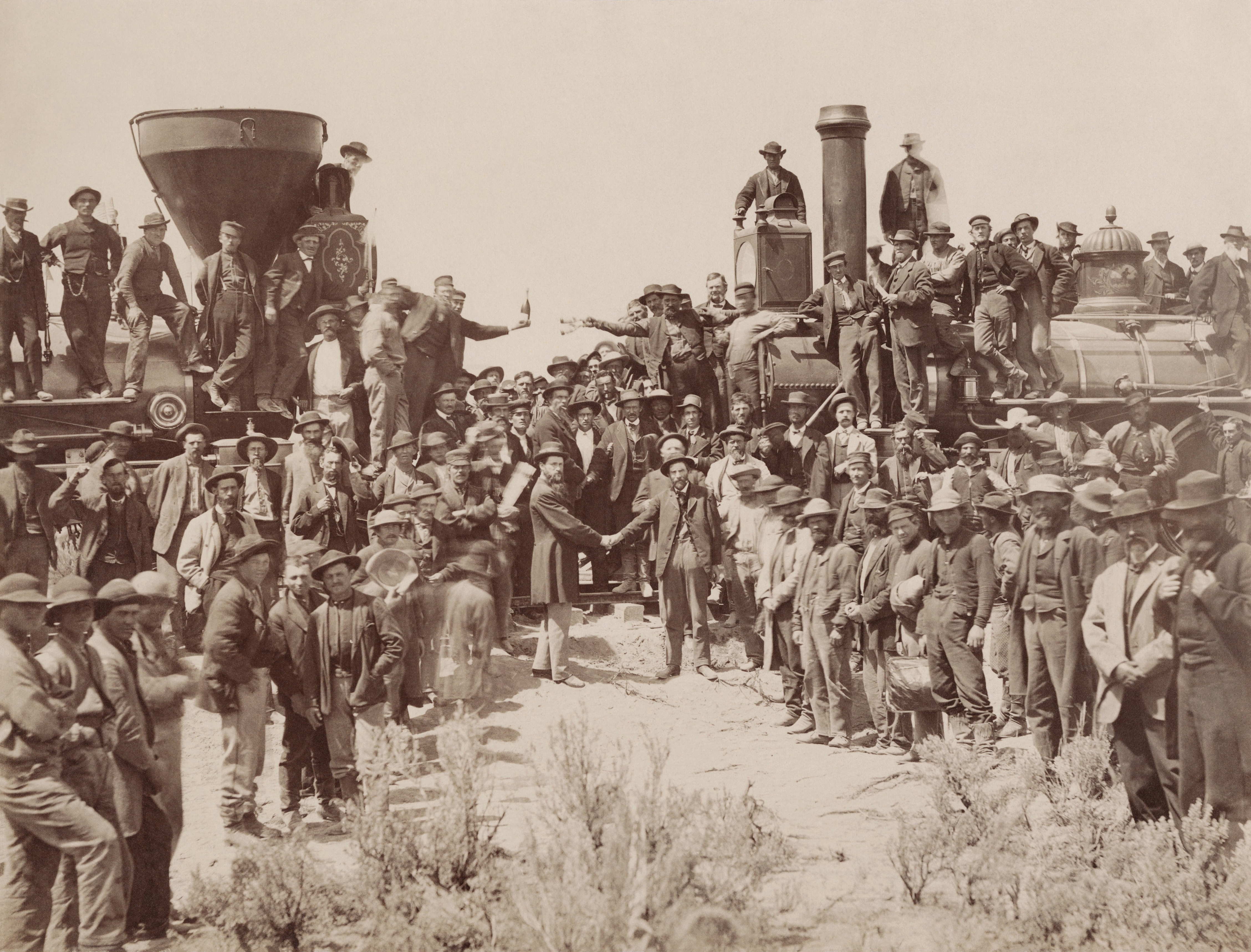 The ceremony for the driving of the golden spike at Promontory Summit, Utah on May 10, 1869; completion of the First Transcontinental Railroad. At center left, Samuel S. Montague, Central Pacific Railroad, shakes hands with Grenville M. Dodge, Union Pacific Railroad (center right).