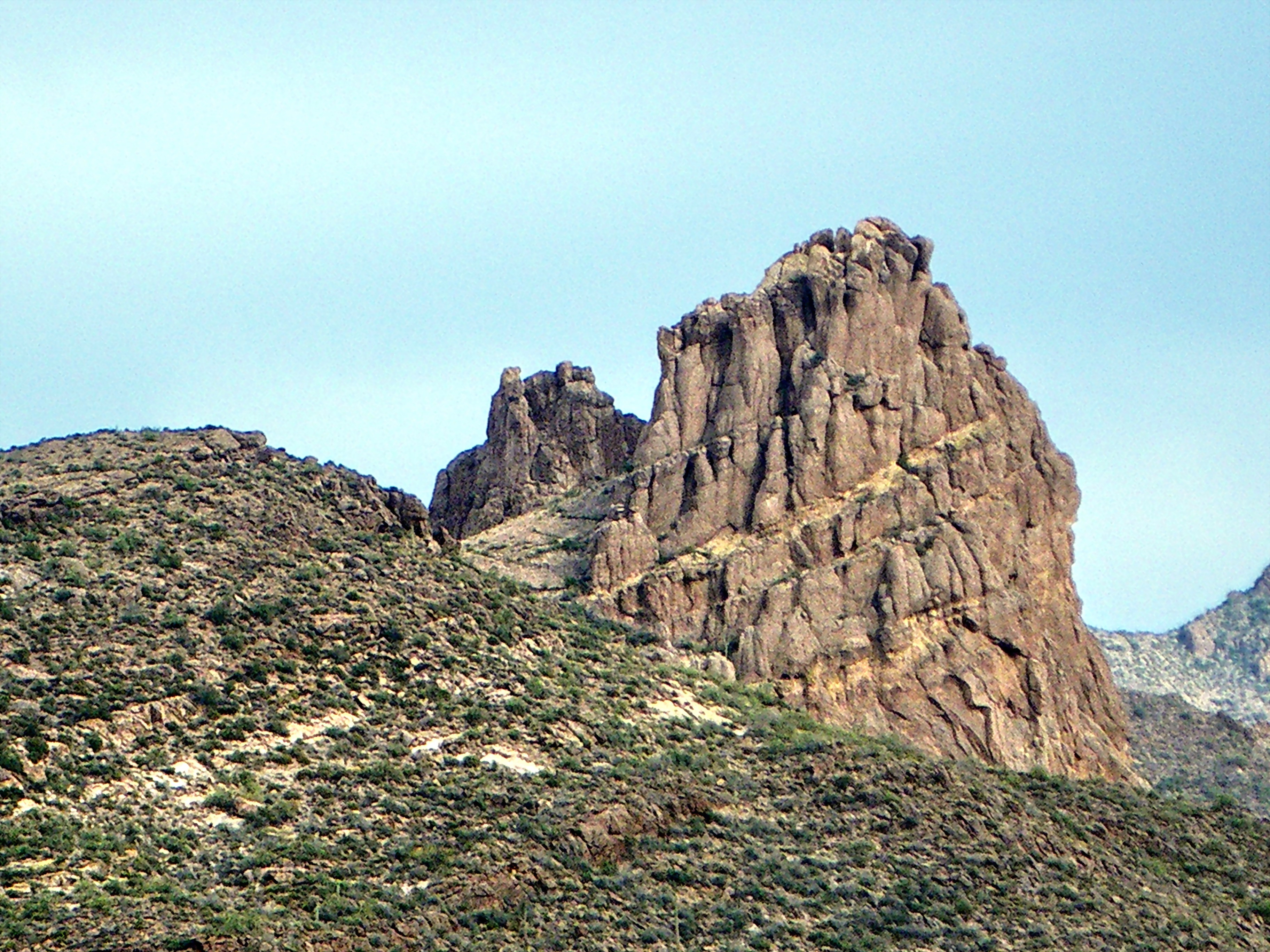 This is the view looking northeast at Miner's Needle from the Bluff Spring Trail. This area figures prominently in the legends of gold in the Supes.  The Lost Dutchman's Mine is thought to be near here. 
I hiked the Charleyboy Duece Loop - the hike shown as Charlebois Loop II in "Hiker's Guide to the Superstition Wilderness" by Jack Stewart and Liz Carlson. 
From Wikipedia:
"The Superstition Mountains, popularly referred to as "The Superstitions" or "The Supes", are a range of mountains in Arizona located to the east of the Phoenix metropolitan area. They are anchored by Superstition Mountain, a large mountain that is a popular recreation destination for residents of the Phoenix, Arizona area.

The mountain range is in the federally-designated Superstition Wilderness Area, and includes a variety of natural features in addition to the mountain that is its namesake. Weaver's Needle, a prominent landmark and rock climbing destination set behind and to the east of Superstition Mountain, is a tall erosional remnant [1] that plays a significant role in the legend of the Lost Dutchman's Gold Mine. Peralta Canyon, on the northeast side of Superstition Mountain, contains a popular trail that leads up to Freemont Saddle, which provides a very picturesque view of Weaver's Needle. Miner's Needle is another prominent formation in the wilderness and a popular hiking destination."