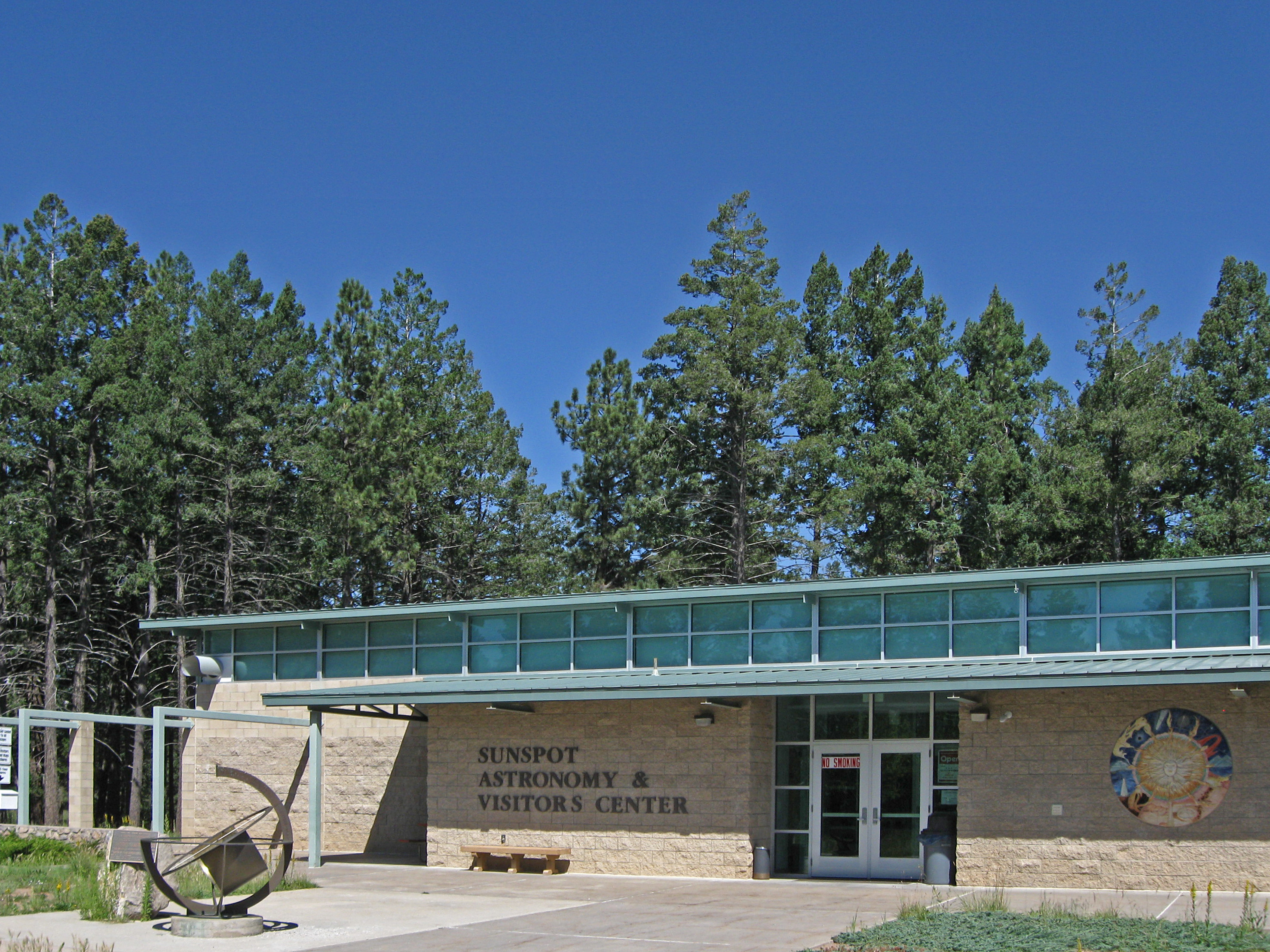 Sunspot Visitor Center and Museum, a joint project between the National Solar Observatory, the Apache Point Observatory, and the United States Forest Service, located in Sunspot, New Mexico. The object in the left foreground is an armillary sphere and sundial
