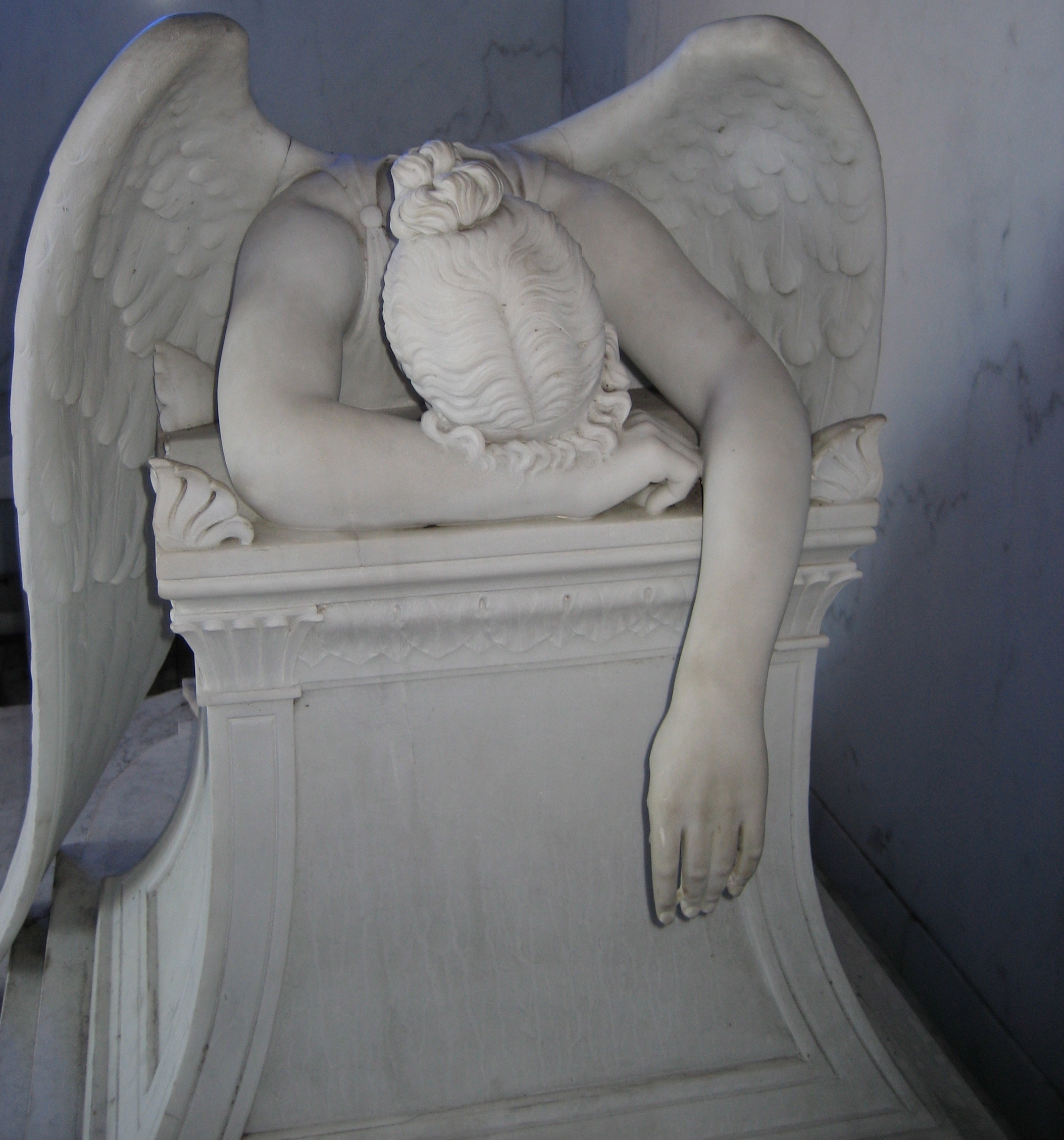 19th century marble sculpture of despondant angel in tomb in Metairie Cemetery, New Orleans. (The sculpture is a copy of  Story's Angel of Grief of  1894 at Cimitero Acattolico (Roma))