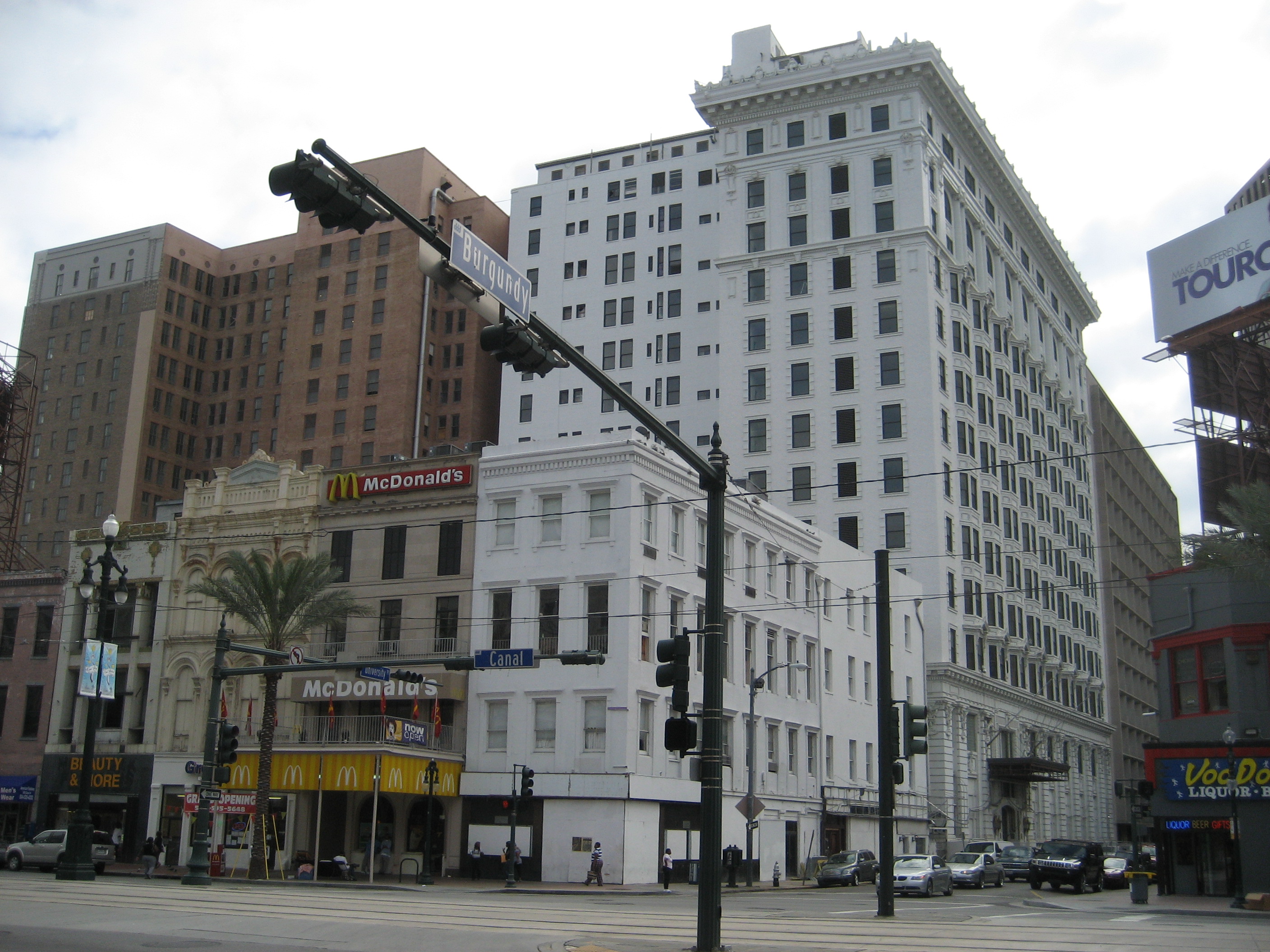 Canal Street New Orleans. Corner at Burgundy with the Roosevelt Hotel Buildings are the high-rises visible just in back of the lower 19th century commercial buildings fronting Canal. A McDonald's fast food store visible.
