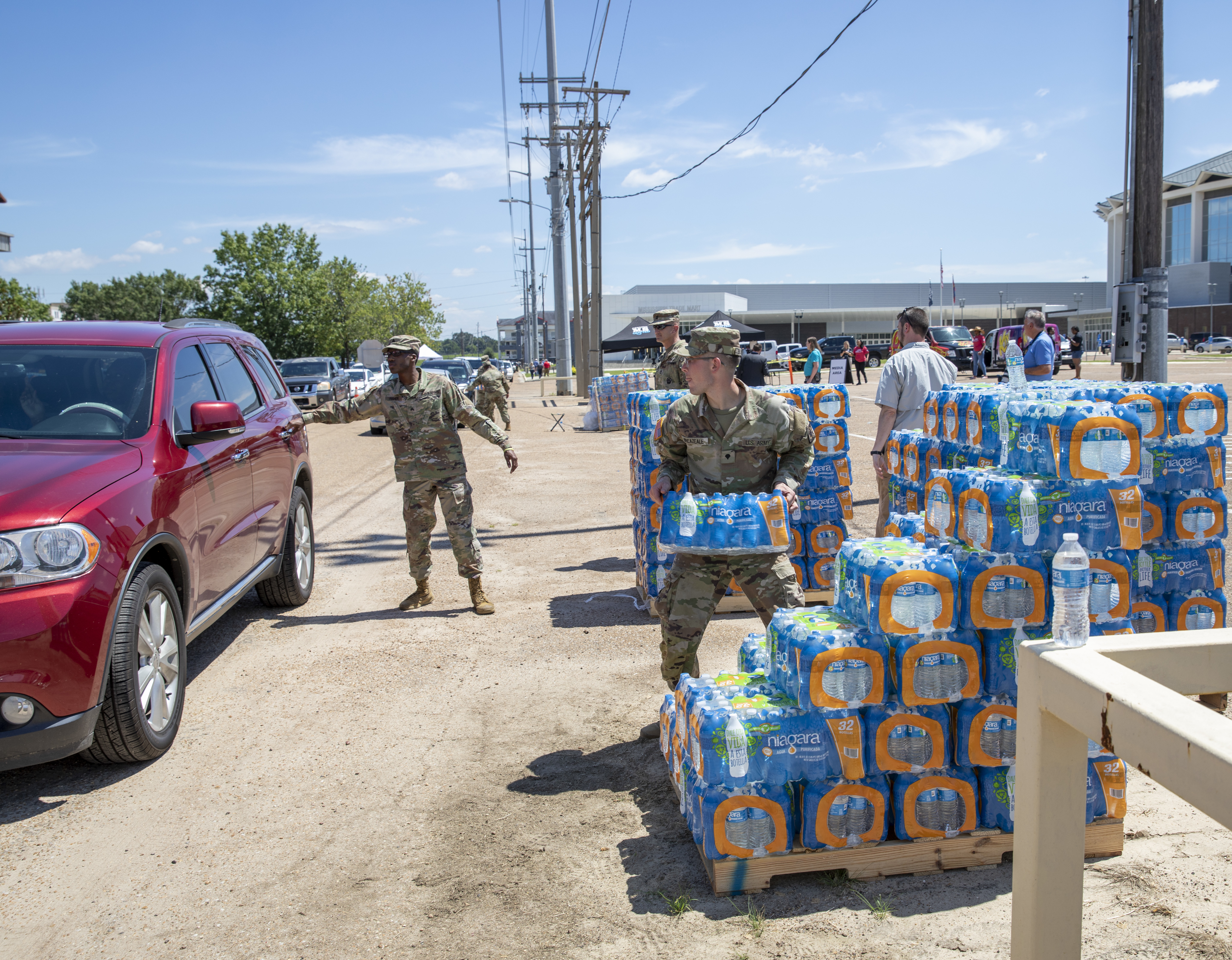 A Mississippi National Guard soldier takes water to a person's car at the Mississippi State Fairgrounds in Jackson, Mississippi, Sept. 1, 2022. Nearly 600 Mississippi National Guardsmen were set up across seven sites through Jackson for people to collect bottled water and non-potable water from water buffalo trucks during the water crisis.
