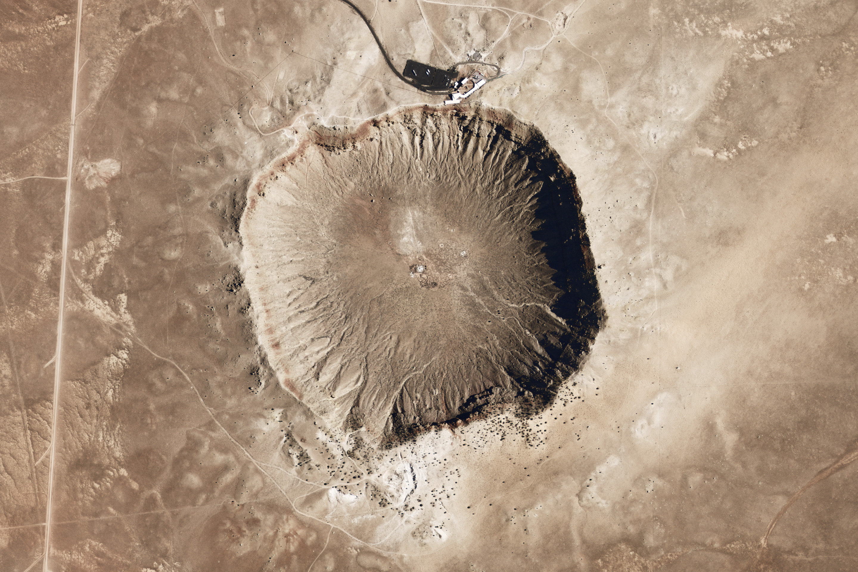 This image has a resolution of 2 meters per pixel, and illumination is from the right. Layers of exposed limestone and sandstone are visible just beneath the crater rim, as are large stone blocks excavated by the impact.