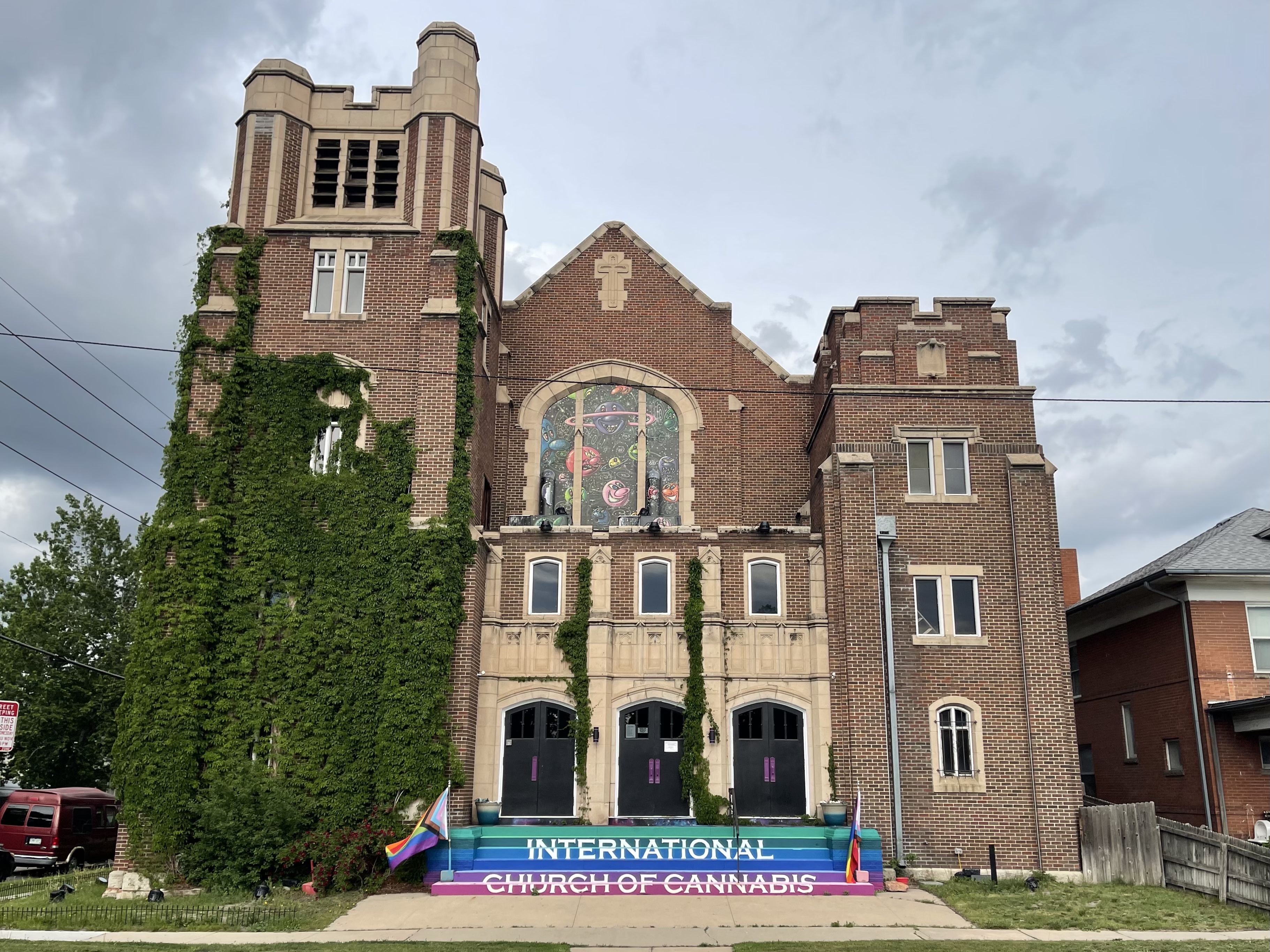 The front of the International Church of Cannabis in Denver, Colorado. Beside the rainbow-colored stairs are two Progress Pride Flags.