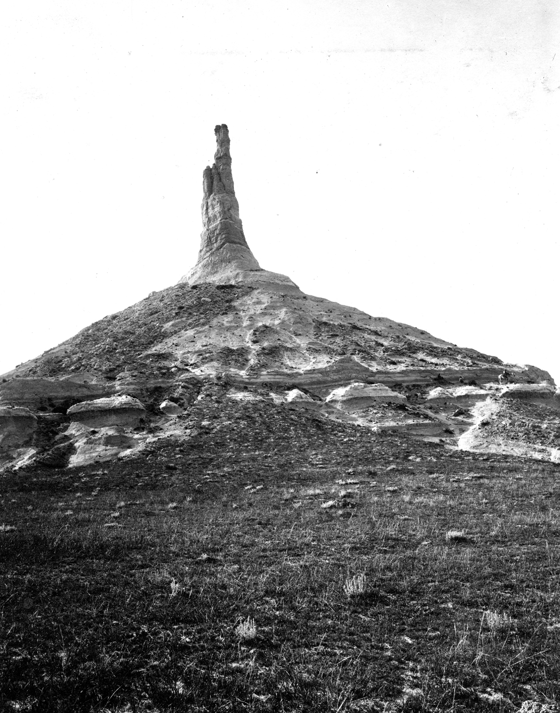 Chimney Rock National Historic Site, Nebraska. Chimney Rock, viewed from the east, west of Camp Clark. Gering Sandstone on Brule Clay. The horse is on a bed of volcanic ash. 1897. Plate 24 B, U.S. Geological Survey Professional paper 17.