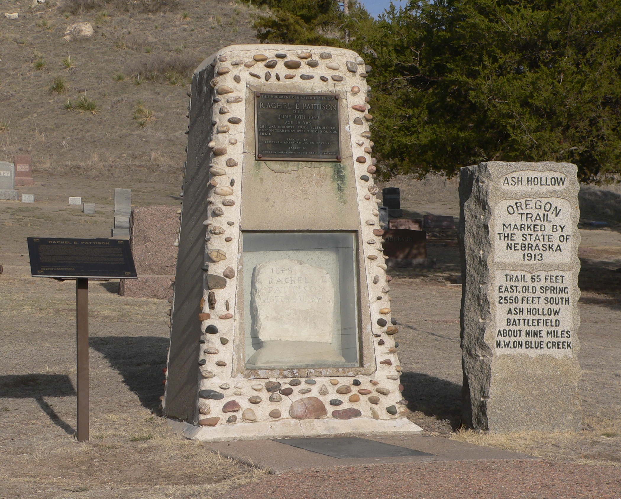 Monuments in Ash Hollow Cemeter, located on U.S. Highway 26 southeast of Lewellen, Nebraska.  In the center is a large monument containing the Rachel Pattison marker; at left is a small interpretive sign concerning Pattison; at right is a 1913 Oregon Trail monument.