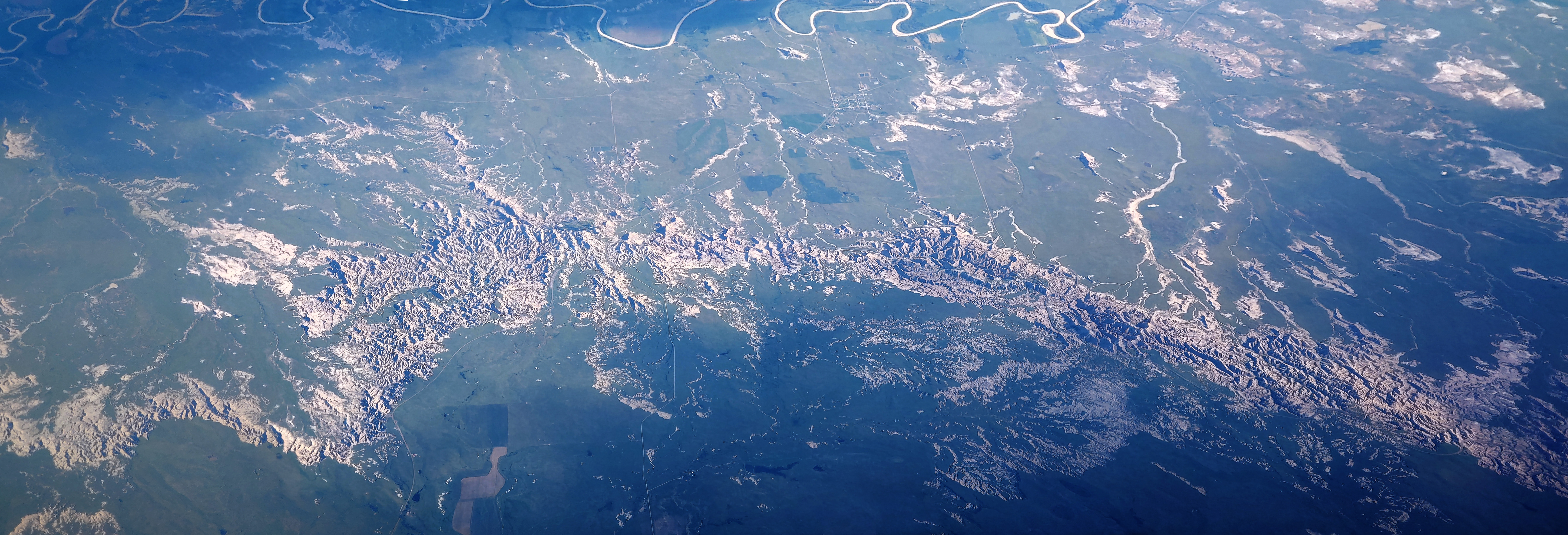 Stitched aerial panorama of Badlands National Park. The White River is to the top. The town of Interior, South Dakota is visible in the upper center.