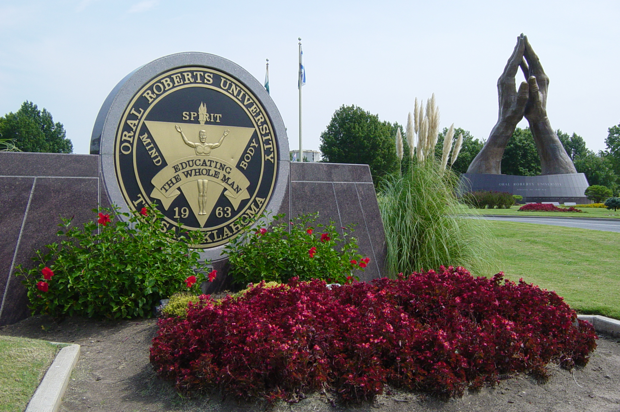 Photograph of the Praying Hands bronze sculpture and the Avenue of Flags at the main entrance to Oral Roberts Universityen in Tulsaen, Oklahomaen.