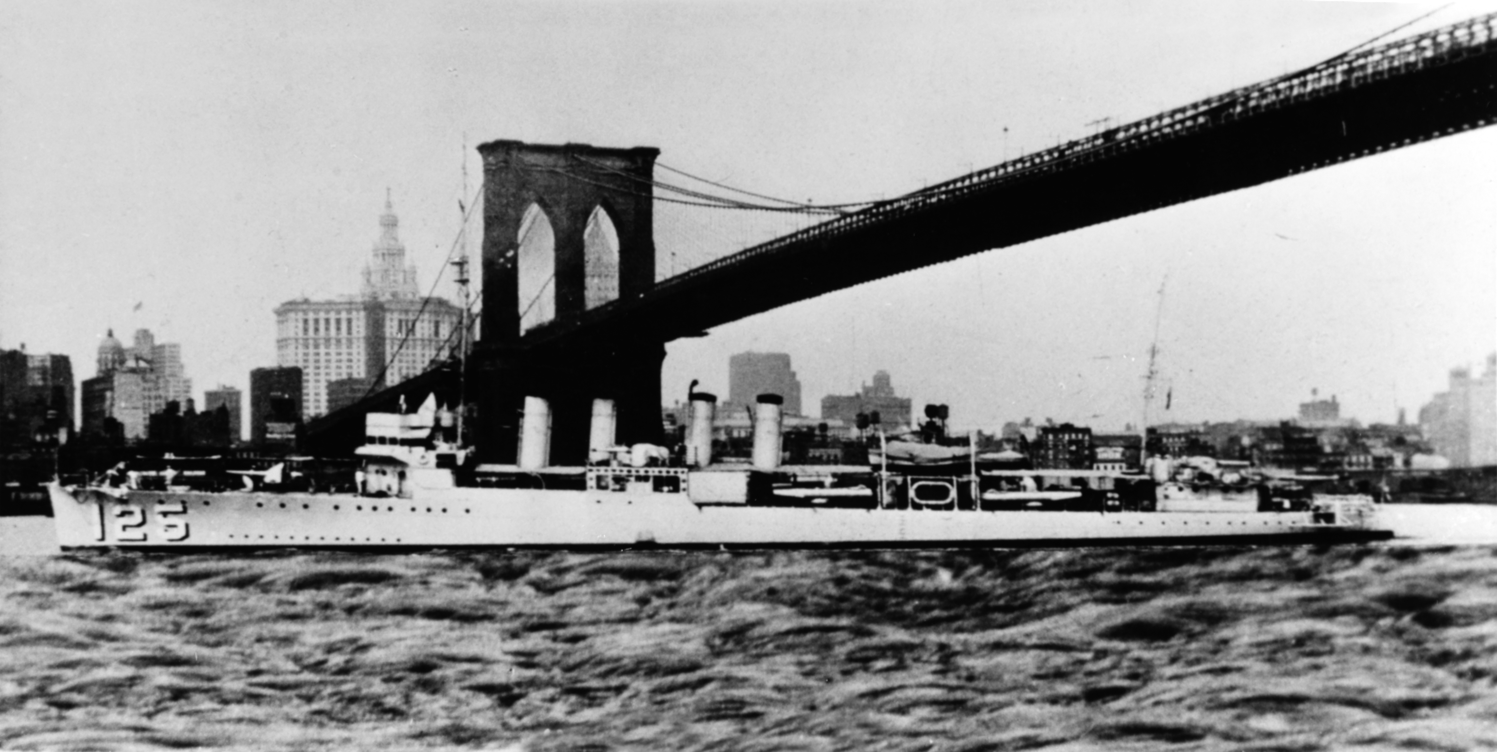The U.S. Navy destroyer USS Tattnall (DD-125) passing under the Brooklyn Bridge, New York City (USA), circa in the 1930s.