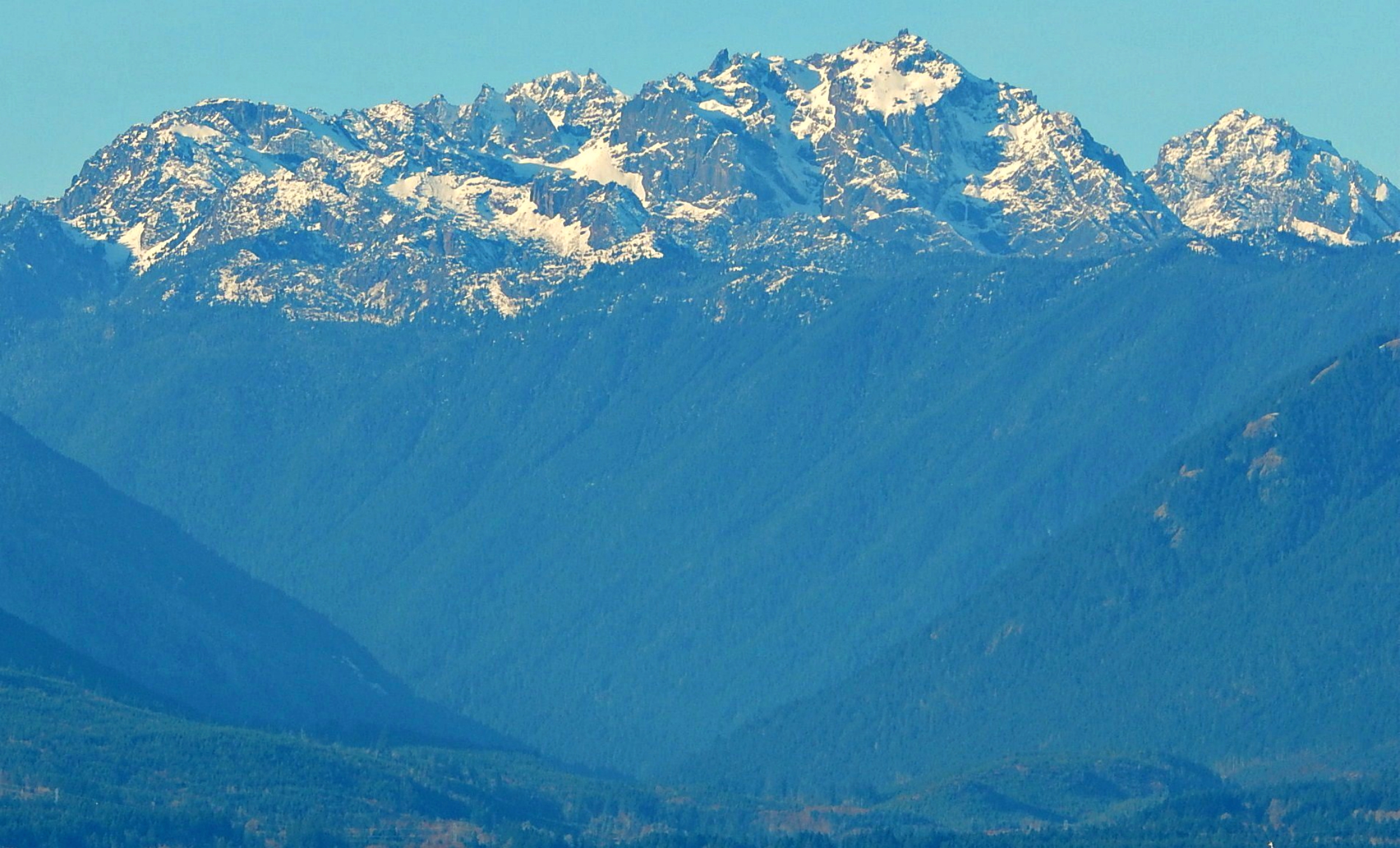 Mount Constance, third highest peak (after Olympus and Deception) in the Olympic mountain range in Washington state. Constance is the highest peak on the Olympic skyline seen from Seattle. This view from Hood Canal.