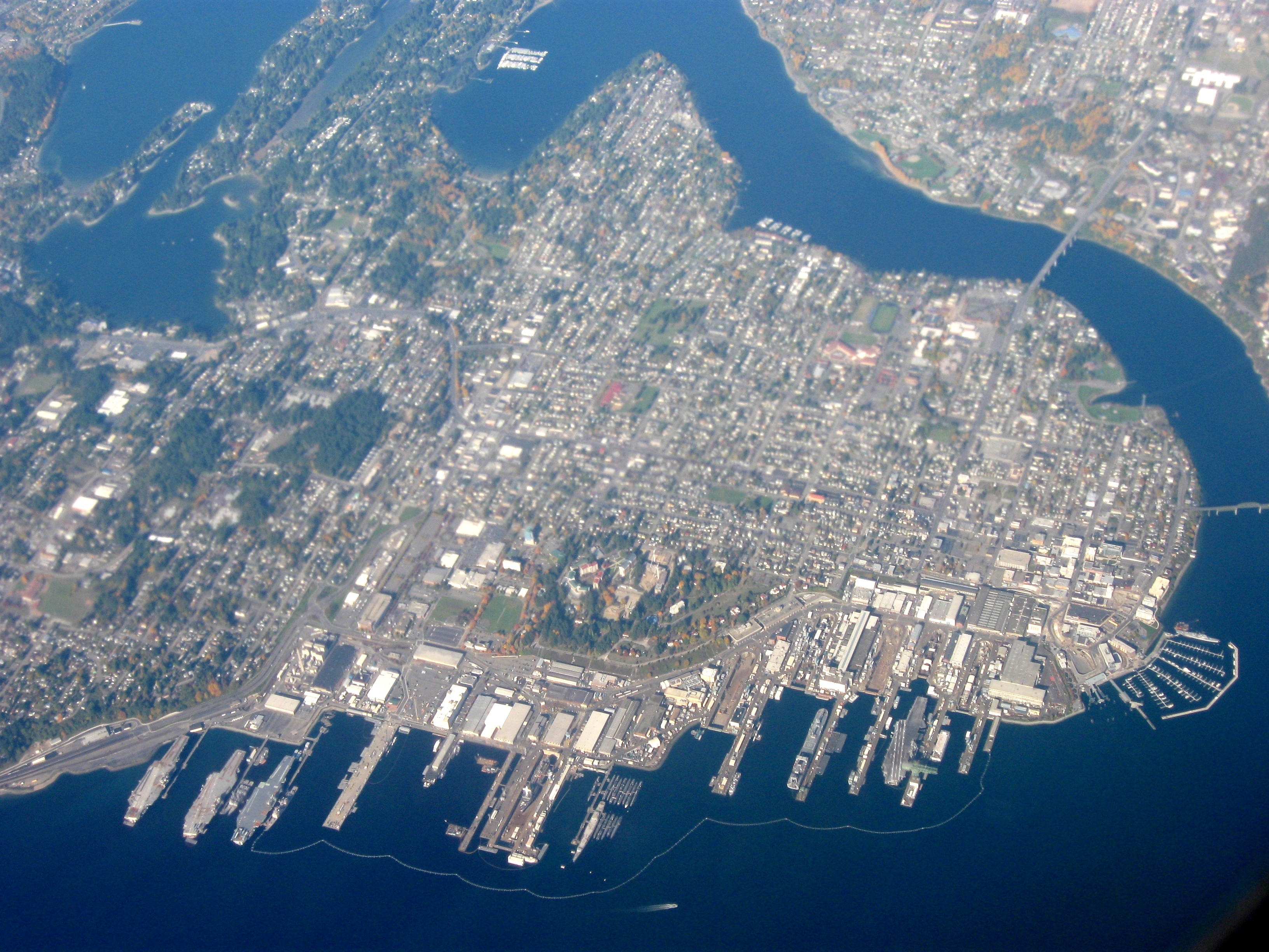 Aerial view of Bremerton, Washington, surrounded on three sides by water, out over Olympic Peninsula, facing northwest.
