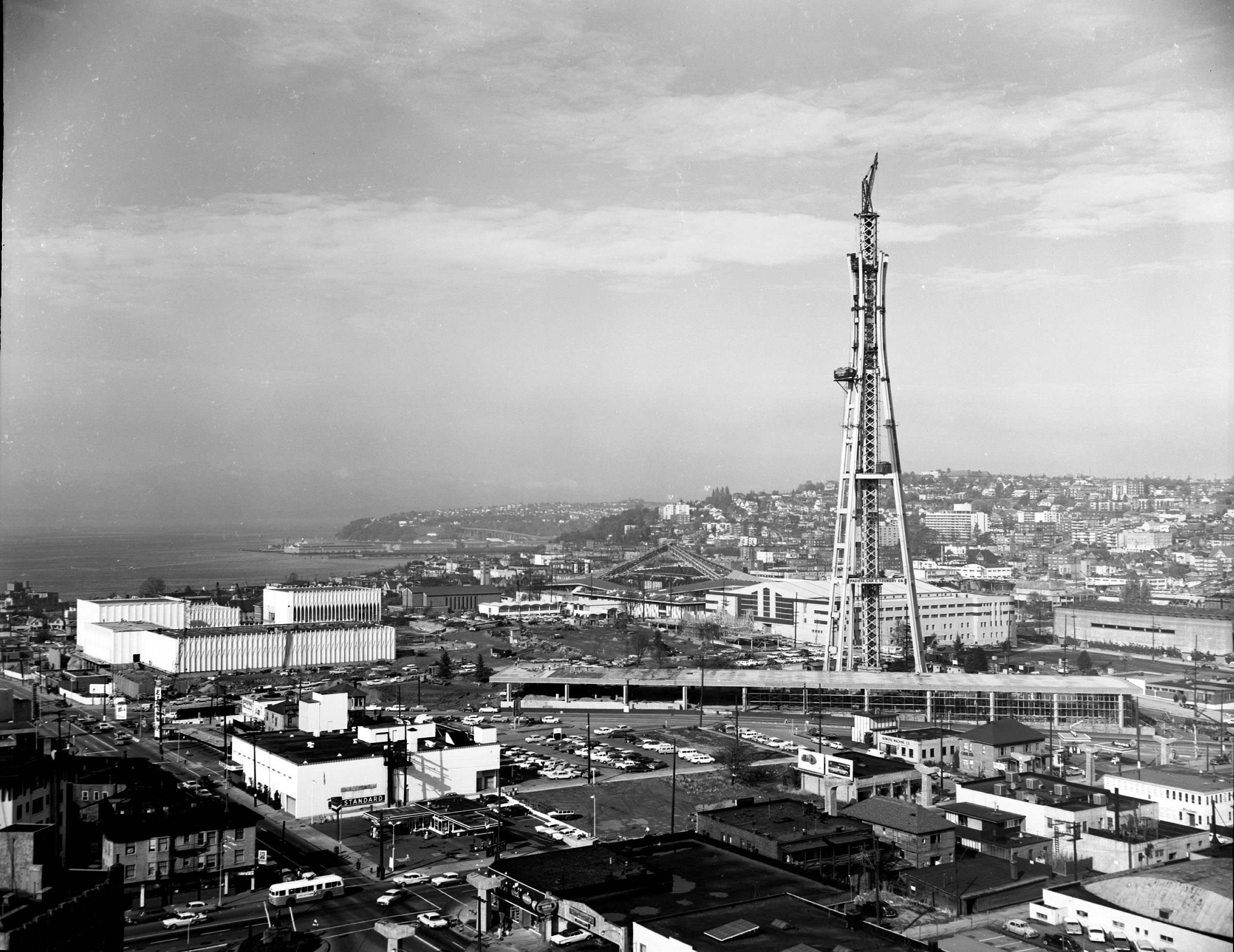 Space Needle (Seattle, Washington, USA) under construction, 1961. This distance shot gives quite a bit of context of a much-changed neighborhood, and also shows the U.S. Pavilion (later Pacific Science Center) and Coliseum (later KeyArena) under construction.