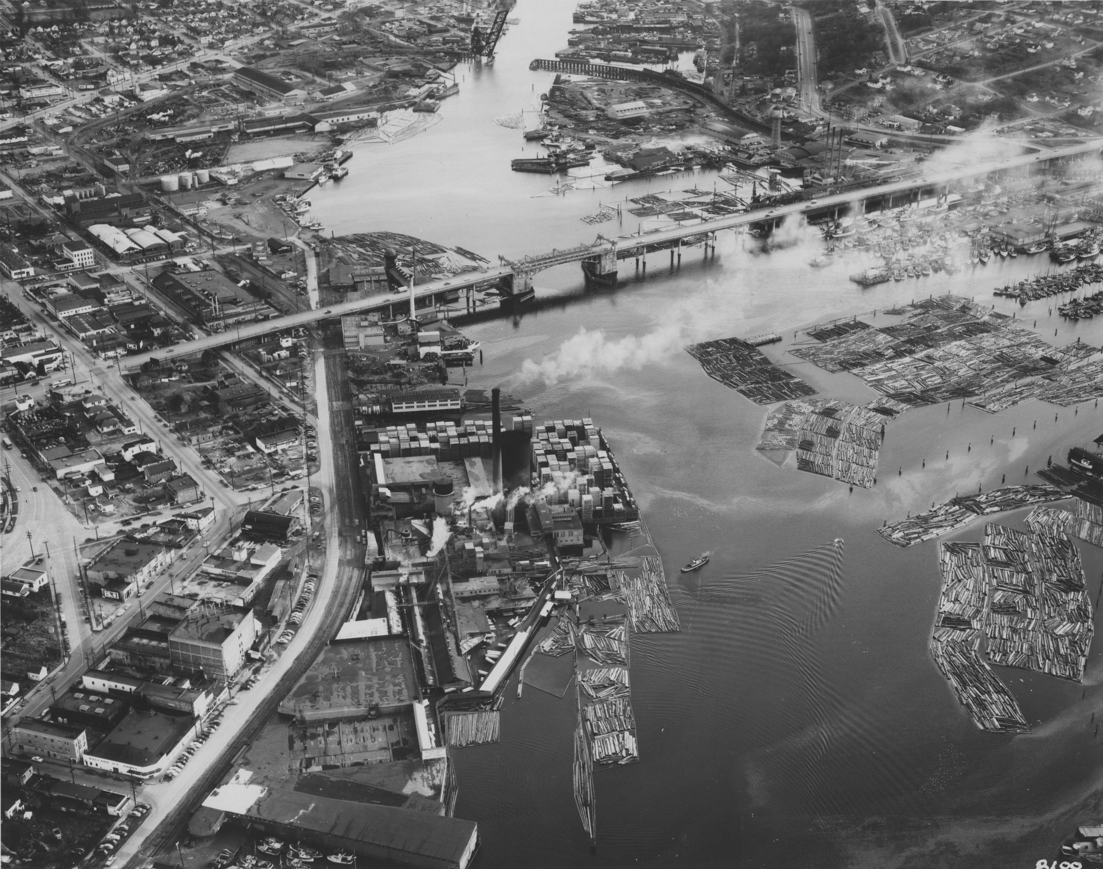 Aerial of Ballard Bridge and Salmon Bay, Seattle, Washington, U.S., 1950. Looking roughly east. At top of frame is the Northern Pacific Railroad Ship Canal Bridge (which was there 1914-1976).