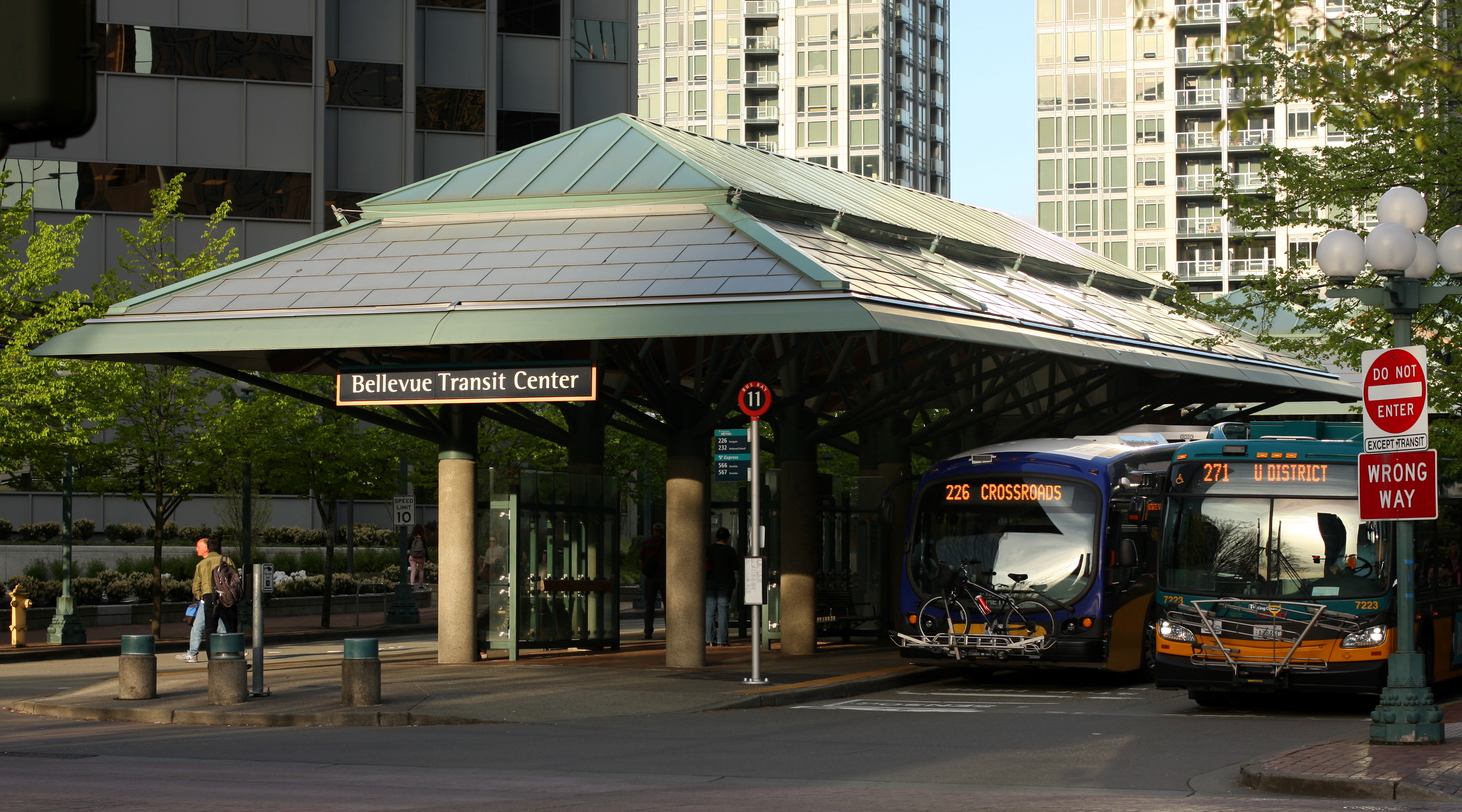 View of the west end of the Bellevue Transit Center from 108 Ave NE. Two King County Metro buses visible on the right.