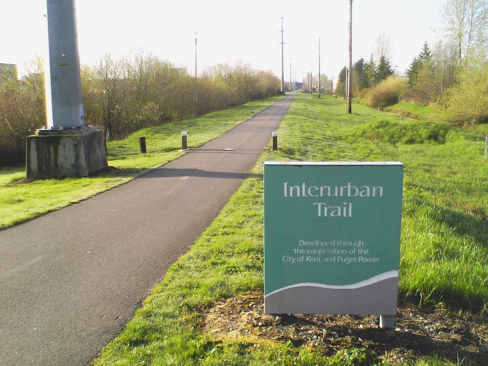 A welcome sign on the Interurban trail in Kent, WA, showing the trail behind.